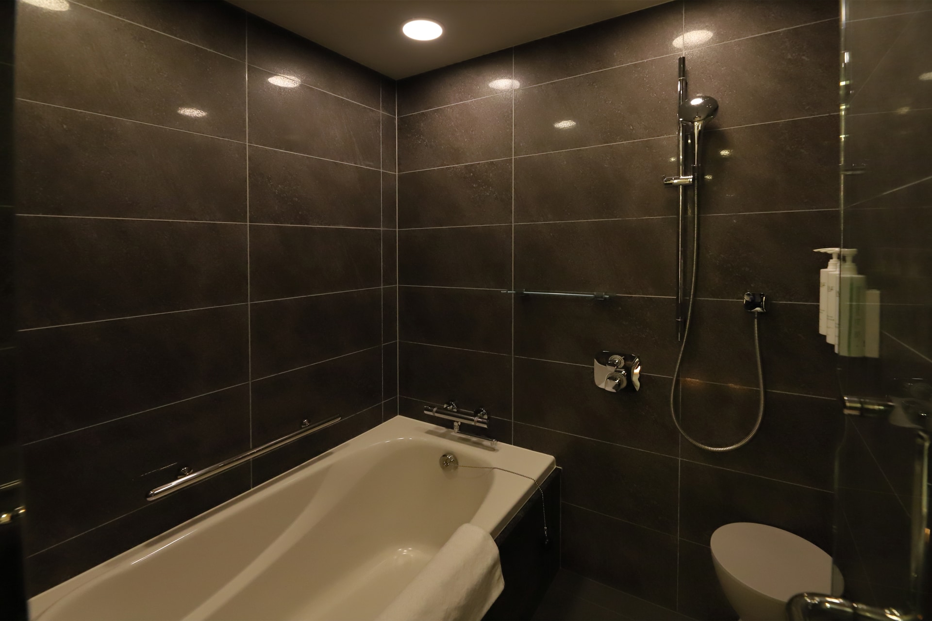 黒御影石のタイルが貼られた高級感のあるバスルーム