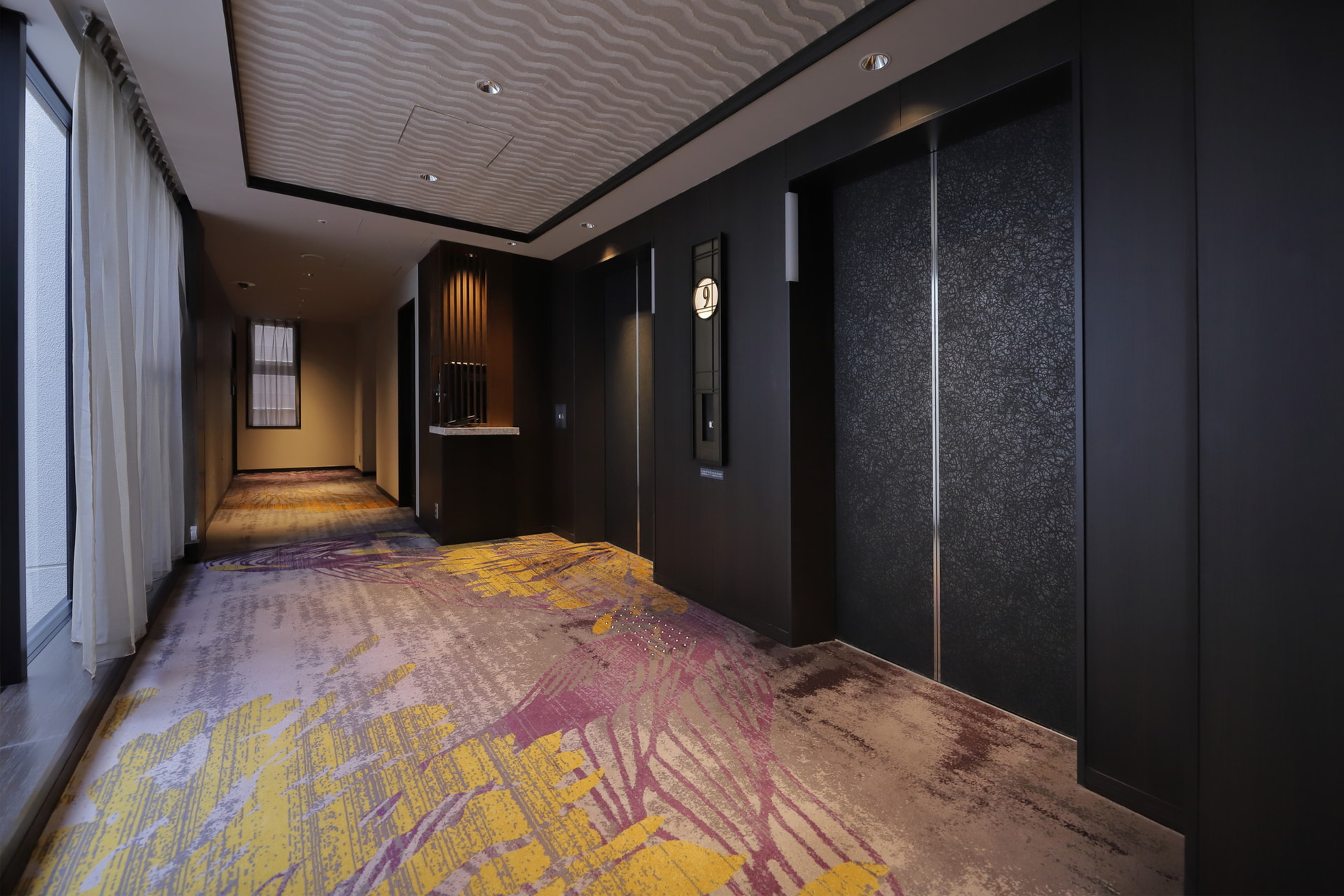 エレベーターホールにはウォーターサーバーを設置。廊下もシックで落ち着いている（写真は9階）