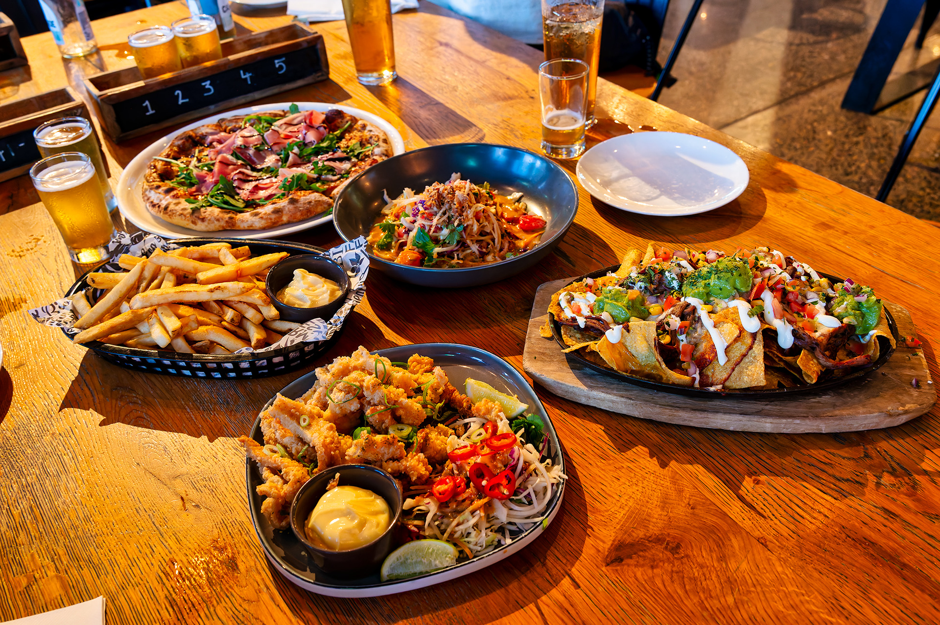 ビール飲み比べメニュー（ビアパドル）は、最大10種類の自社醸造ビールを含む20のタップから選べる。例として、Pitchfork Betty Pale AleやWest Coast IPA、FNQ Resilience Lagerなど、個性的な味わいが楽しめる。各ビールの特徴や風味を解説するテイスティングノートが提供され、初心者でも楽しみながら学べる。美味しい料理とともに堪能したい