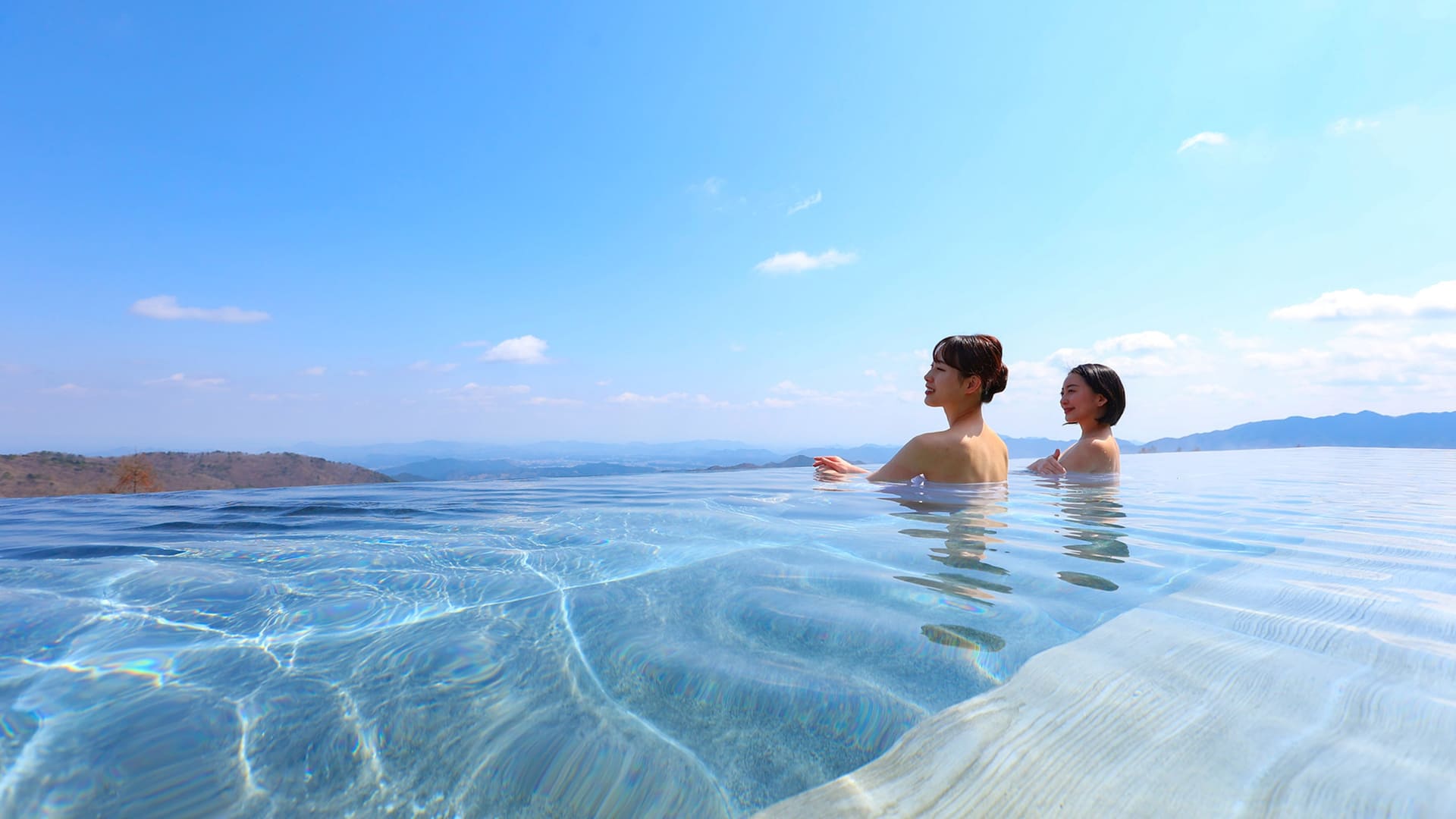 大浴場のインフィニティ露天風呂。霧降高原の森と空の絶景を見渡す