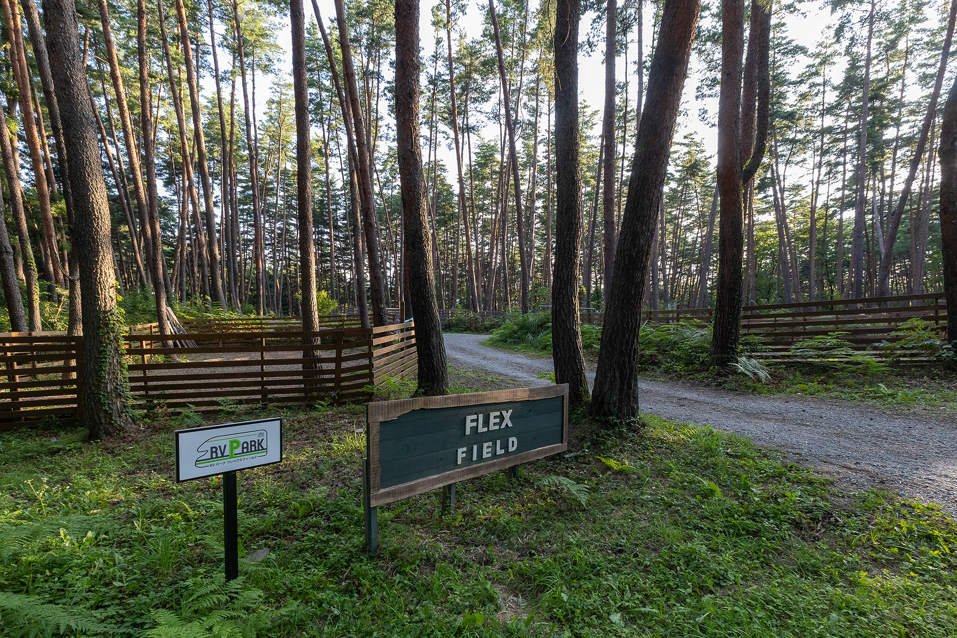 フレックスフィールドへは、FOLKWOOD VILLAGE八ヶ岳のセンターハウスからは一度道路に出て、別の入口から入る。写真は炊事棟やドッグサイトがある上段エリアの入り口。高低差がない