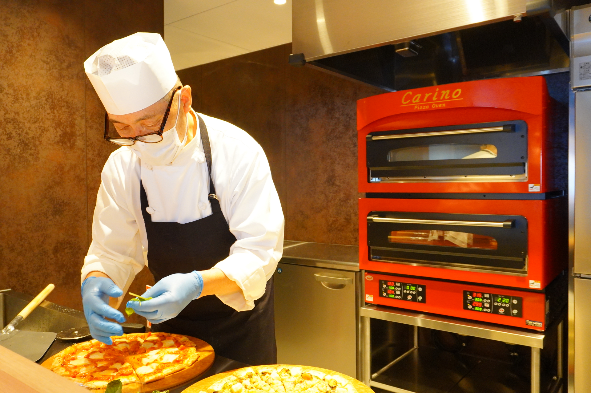 オーブンで焼き上げるピッツアは、マルゲリータとバジルソースのペスカトーレ