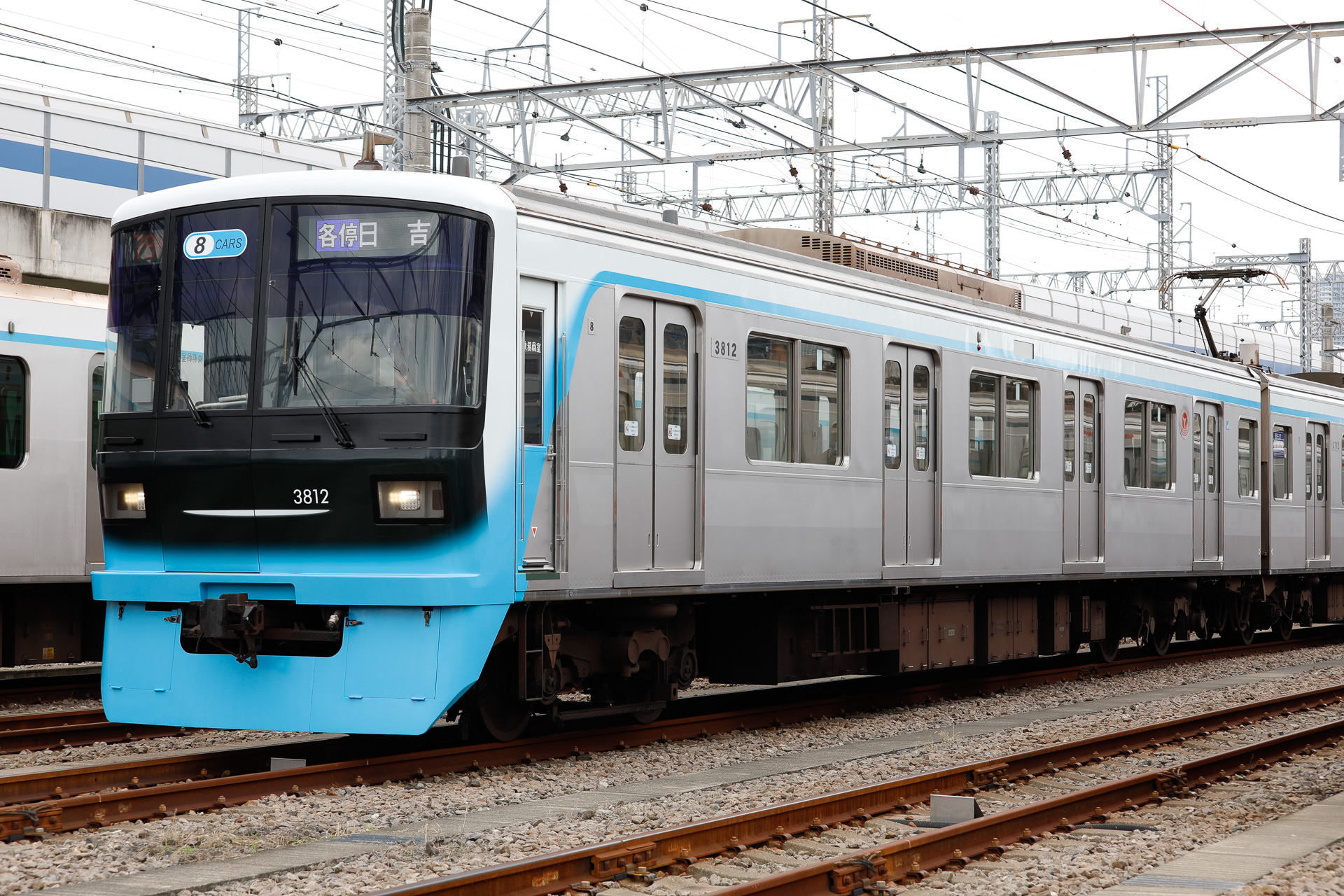 日吉・新横浜方先頭車の3812号車を側面寄りから。側面の窓上に、白と水色と、二色の帯を通している様子が分かる