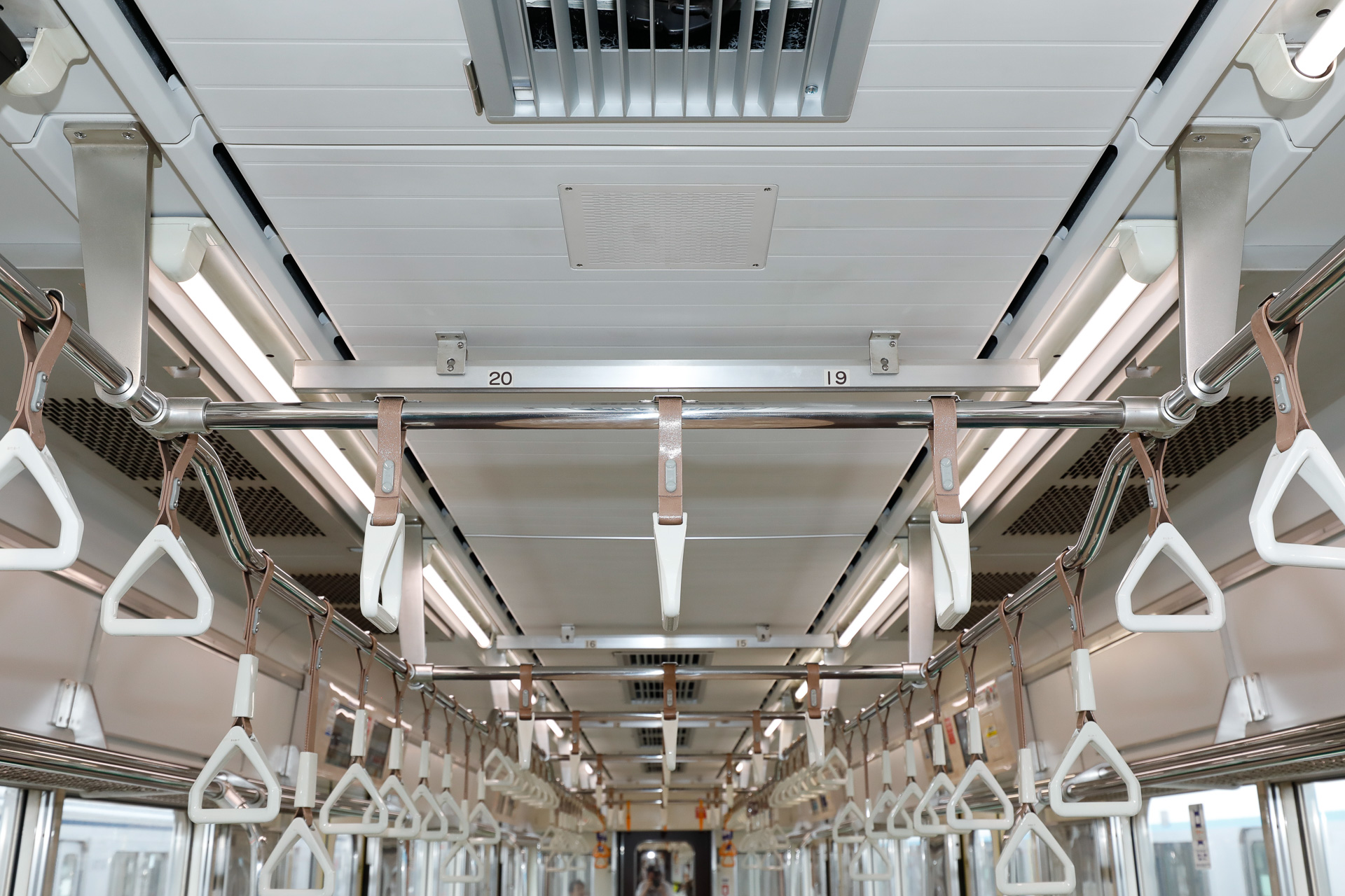 1～3号車と6～8号車の天井まわり。三角形（厳密にいうと五角形だが）の白い吊手が使われている