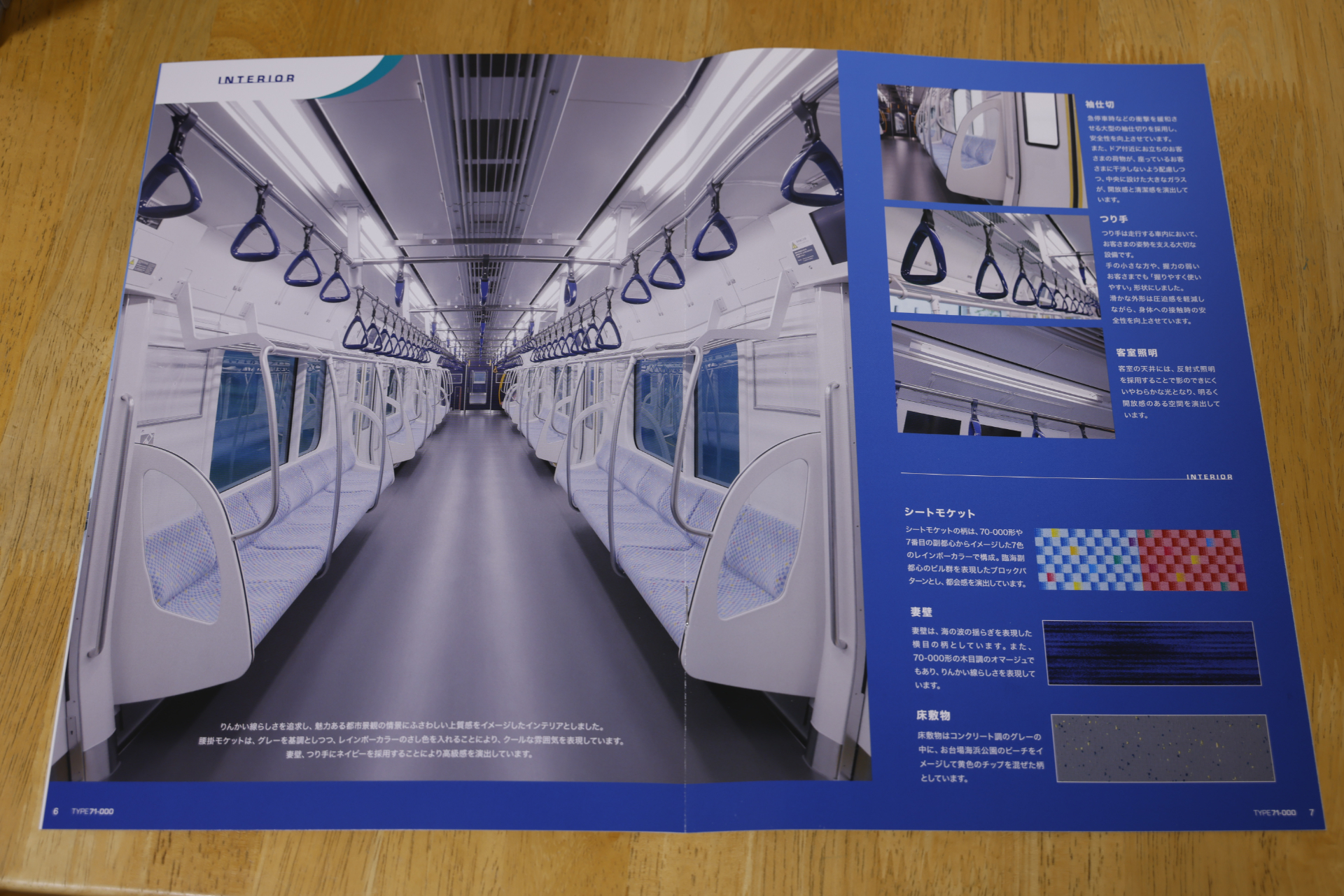 71-000形のパンフレットに載っている車内の写真。端部の席に座っている乗客と、その横の立客の干渉を防ぐ大型袖仕切は、今では標準的な装備。もちろん、バリアフリー設備の強化も図られている
