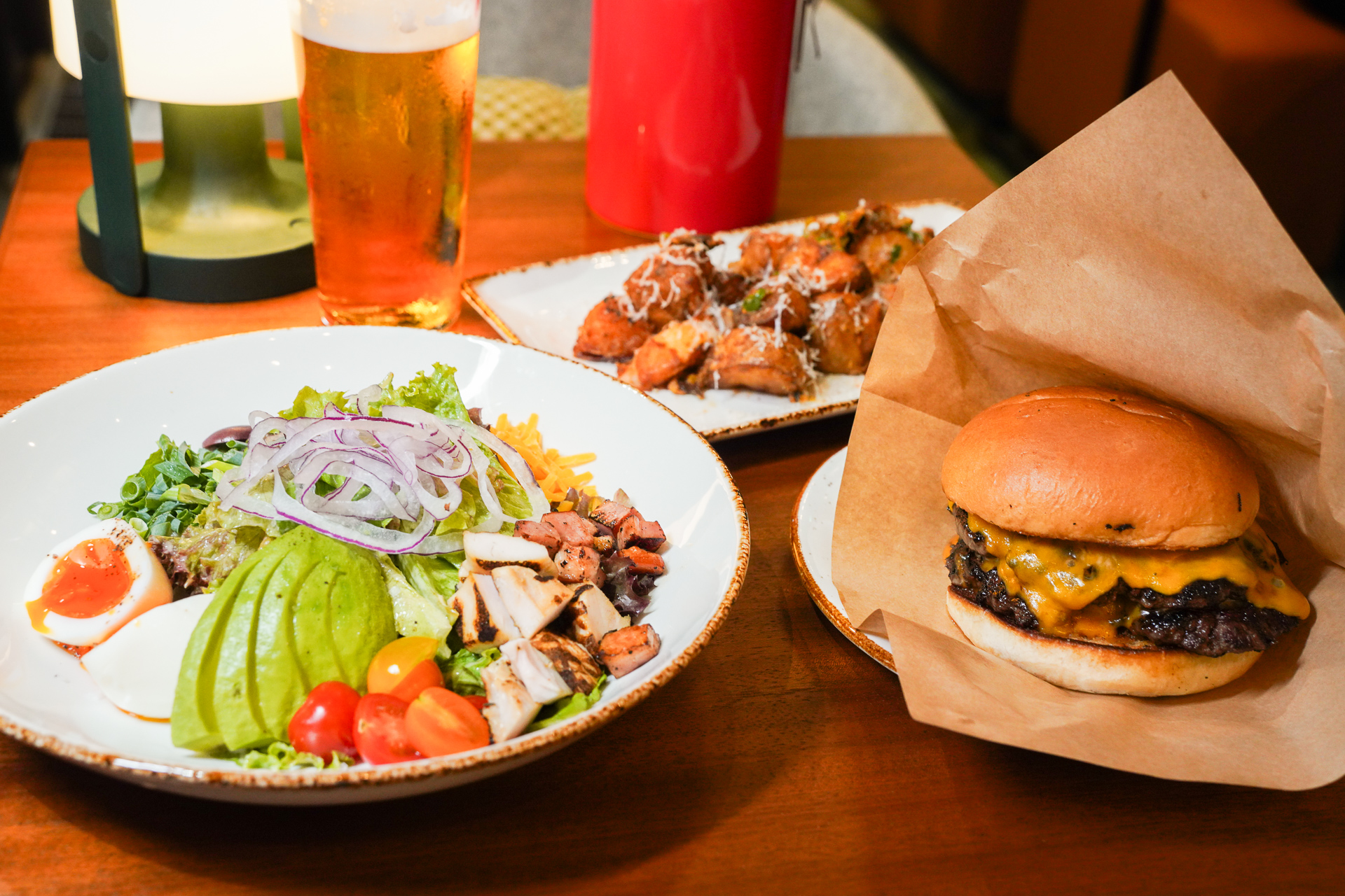 夜メニューで試食した「ザ・スマッシュ」と「コブサラダ」。奥は「ハラペーニョパルメザンチーズ」はビールが進む味付け