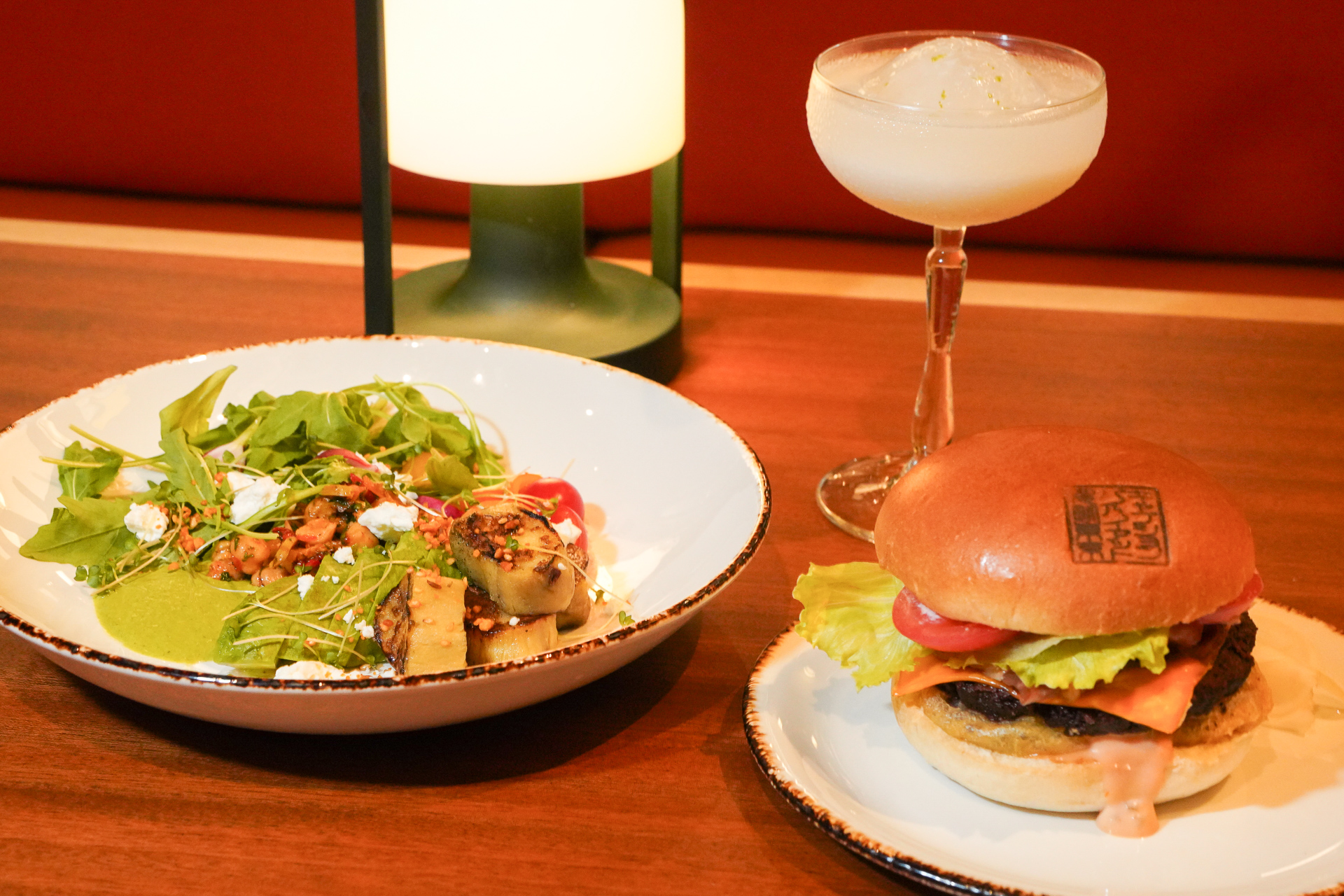 別の夜メニューのバーガー「@キャプション」と「ブッダボウル」、カクテルは「平和トークショップ」