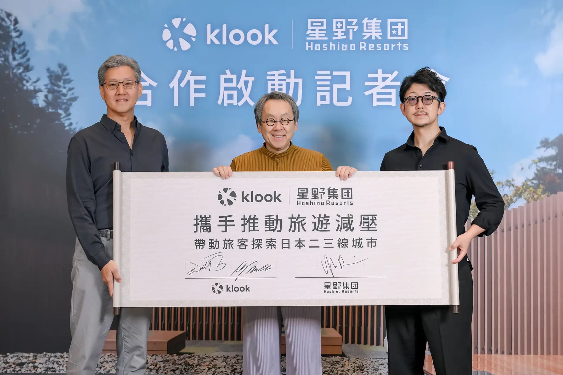 From left: Wilfred Fan, CCO of Klook Travel Technology Limited; Yoshiharu Hoshino, CEO of Hoshino Resorts; and Wataru Masuda, General Manager of Klook Japan. The panel behind them outlines their commitment to promoting travel and reducing barriers.