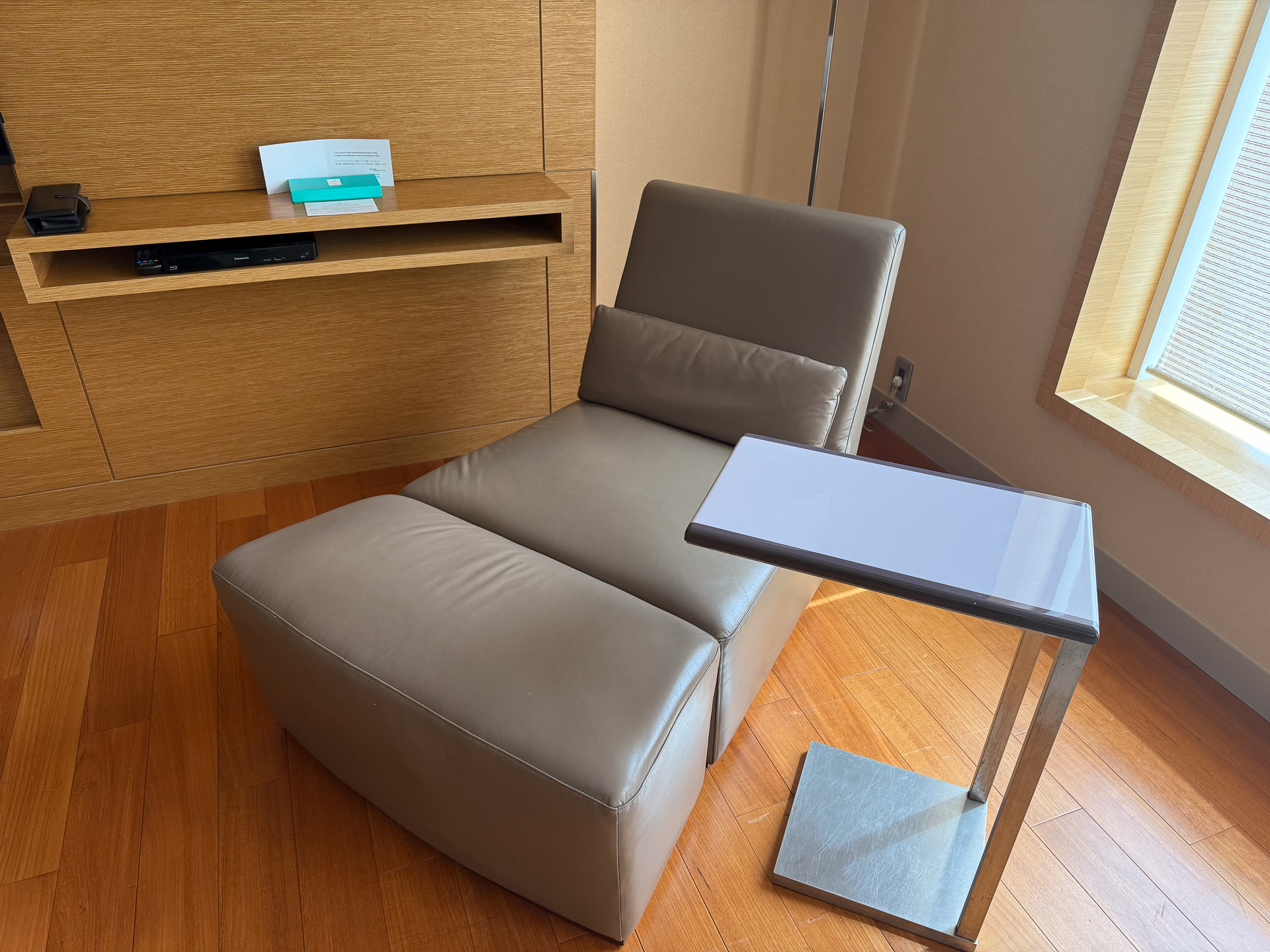 The room is furnished with a sofa and ottoman (left) and a daybed (right), allowing guests to relax as they whether enjoying a drink or lounging after a bath.