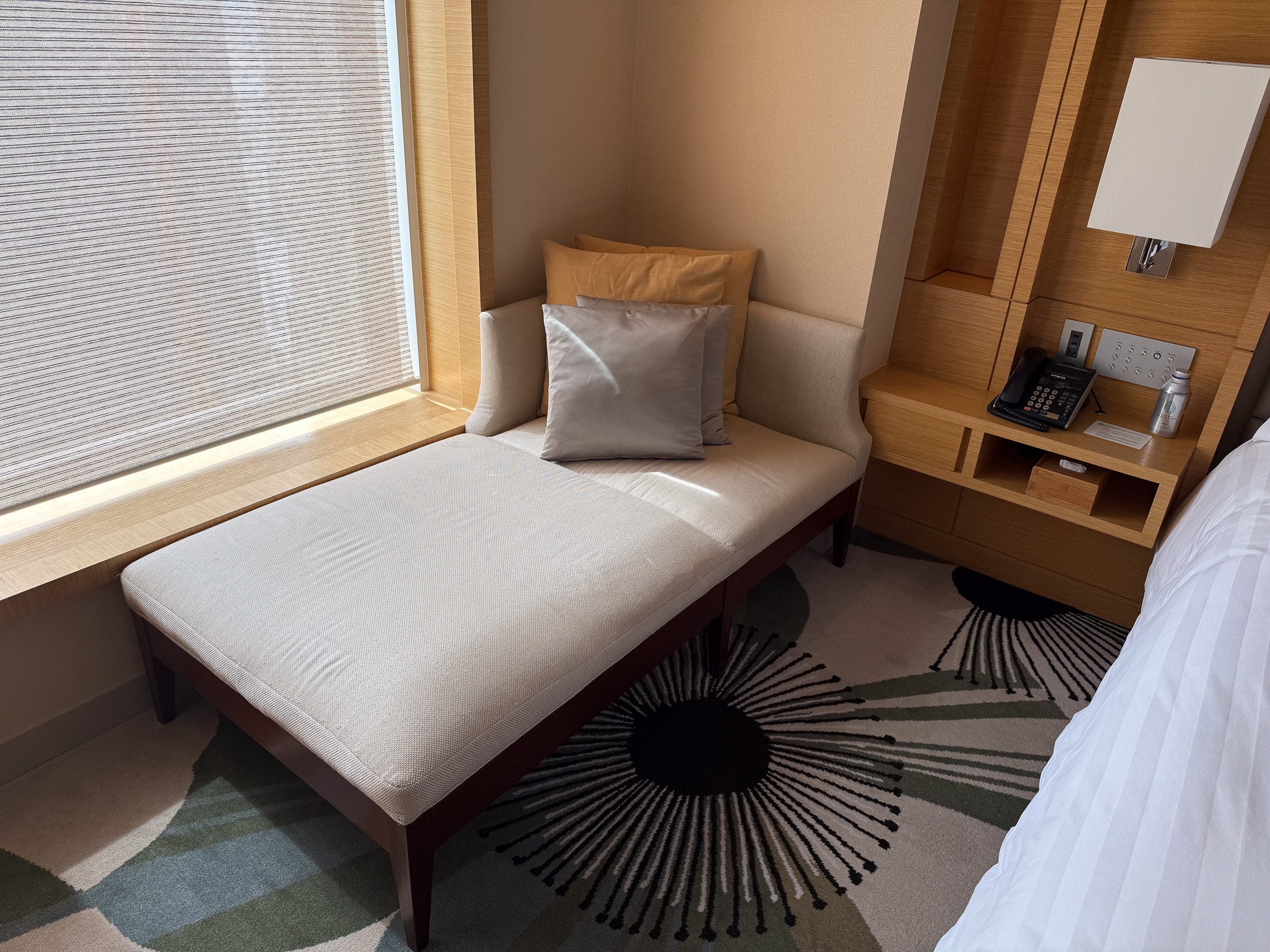 The room is furnished with a sofa and ottoman (left) and a daybed (right), allowing guests to relax as they whether enjoying a drink or lounging after a bath.