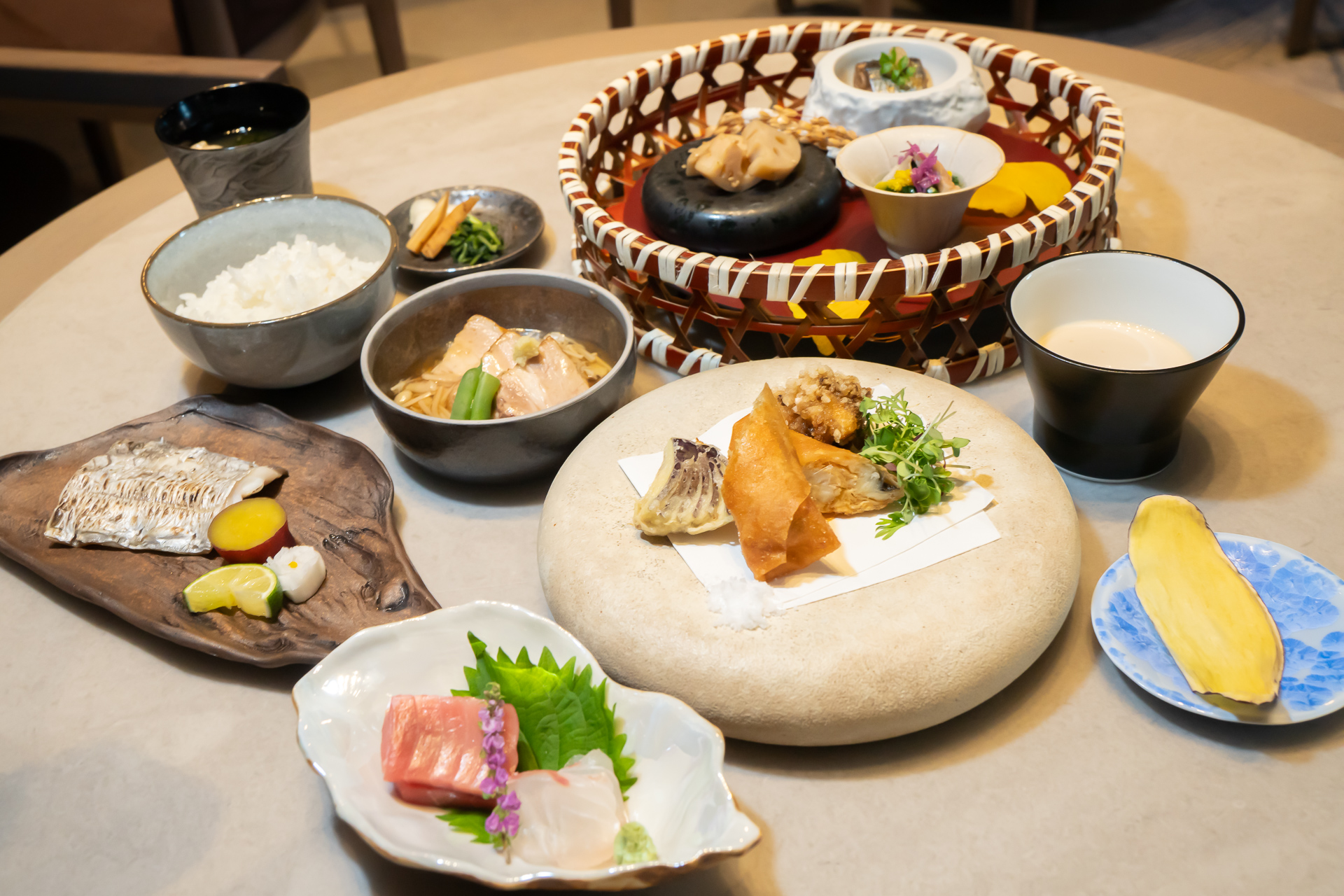 ランチコースメニュー「慶香」（1万2000円）。小鉢（菊菜お浸し 春菊 黄菊 蟹、蓮根金平、秋刀魚山椒煮 大根）、御造り（鰹と天然鯛 妻いろいろ）、焼き物（太刀魚塩焼き 薩摩芋檸檬煮 酢取り野菜）、煮物（黒豚角煮 茸あん 隠元 生姜）、揚げ物（穴子の春巻き 舞茸の香煎 茄子）、食事（新米 味噌汁 香の物）、水菓子（ほうじ茶ゼリー 薩摩芋チップ）