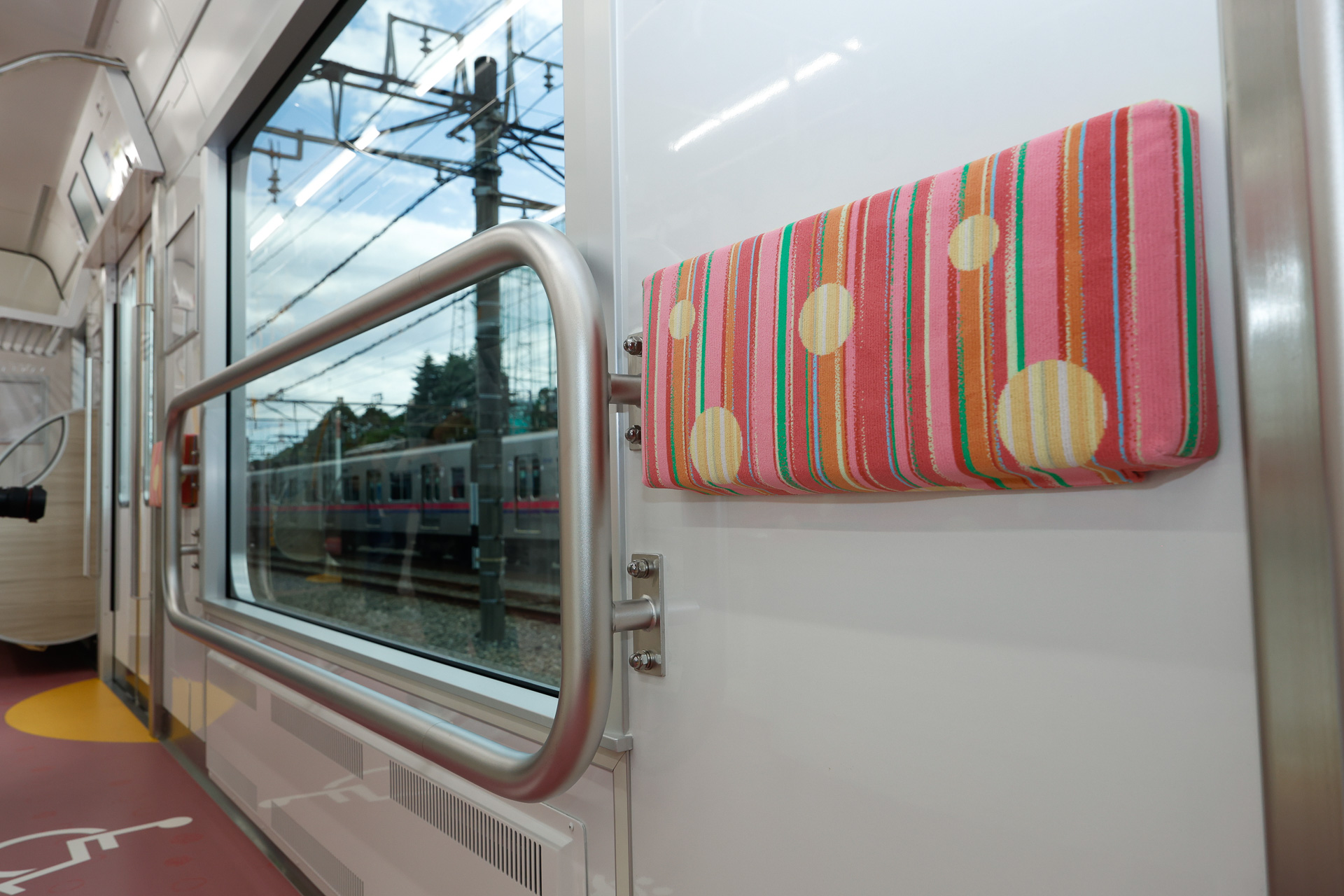 「ひだまりスペース」だけ側窓が下方に拡大されており、そこに「口」の字形の手すりが設けられている。これなら背が低い子供でも大丈夫。この手すりはおそらく、混雑時にガラスが破損しないようにガードする機能も担っているのだろう