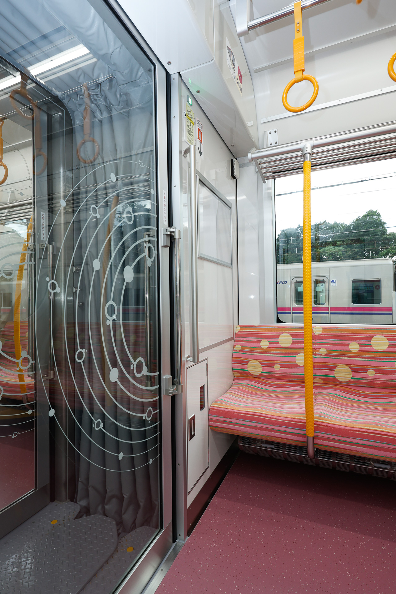 貫通路の扉はガラス製で、扉の存在を視覚的に把握できるようにマーキング入り。そのマーキングも、外装と軌を一にした「円」を主体とするデザイン