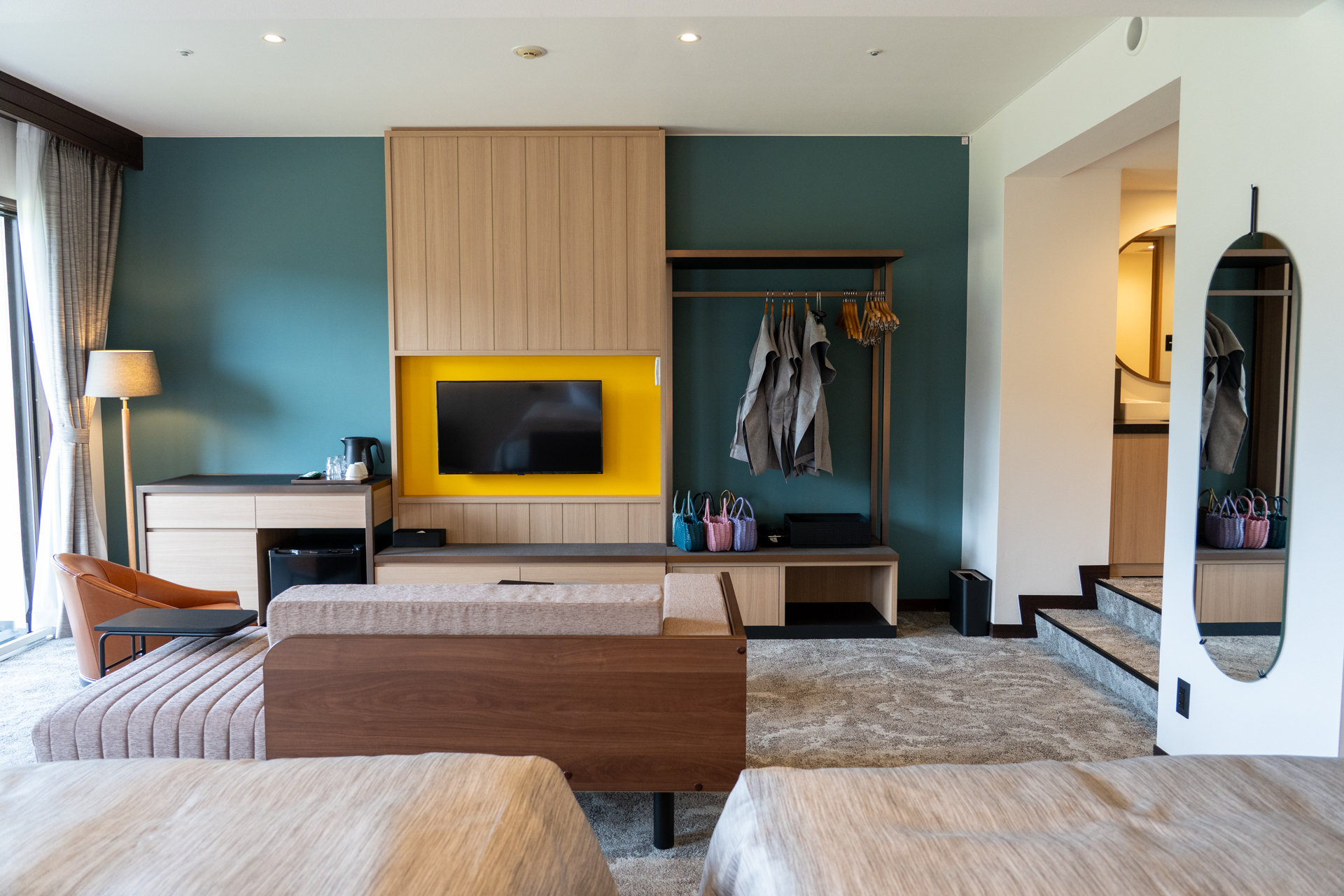 木の質感にこだわった客室。正面のグリーンの壁紙が落ち着く