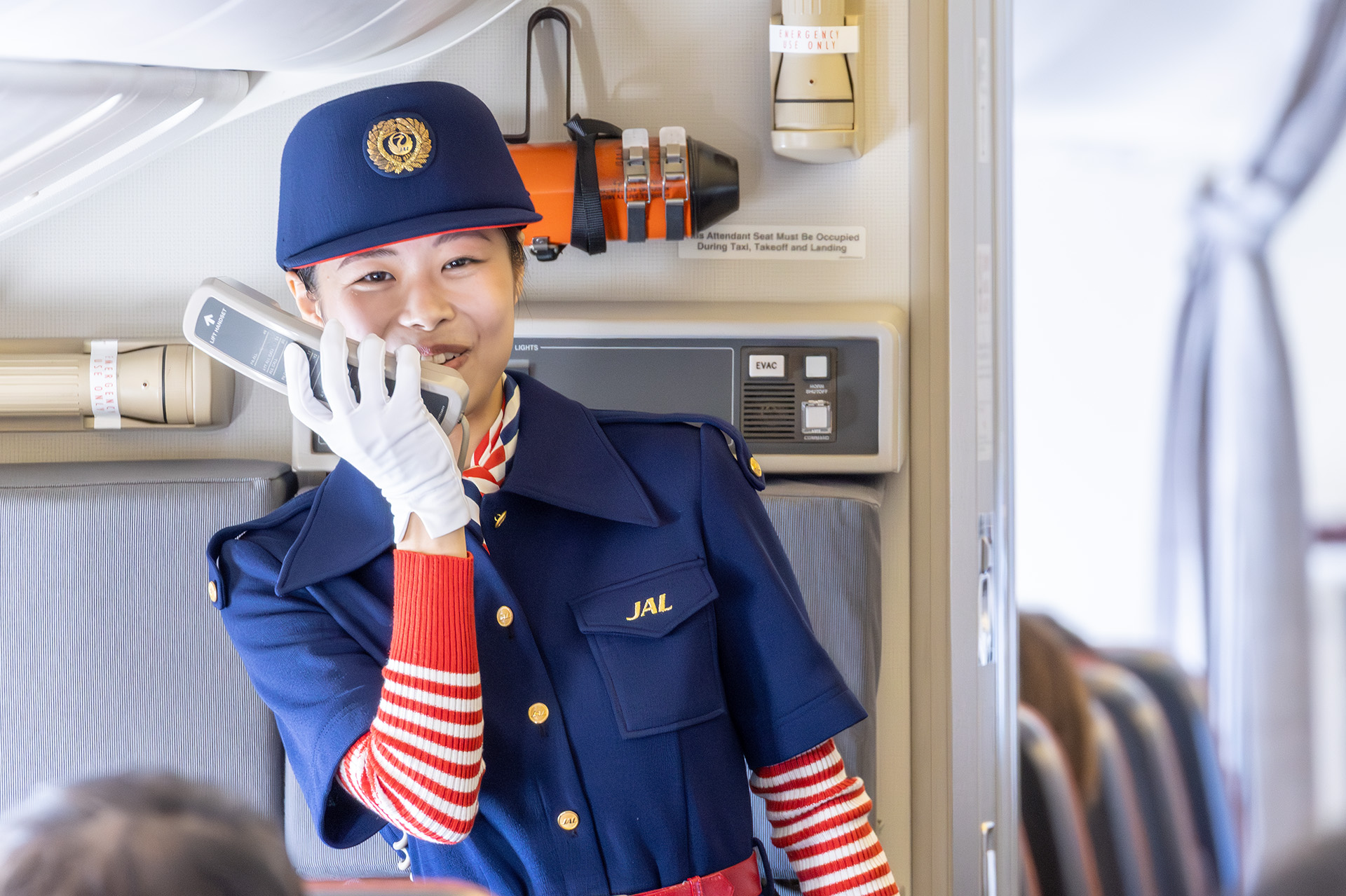 8名の客室乗務員とともに6～8代目の制服を着る乗務員も。森英恵氏による6代目（1977年10月～1987年12月）。着用した八木祐望氏は「現行の制服よりもアイテムが多くなっておりますので個人的には忘れ物が少し心配」