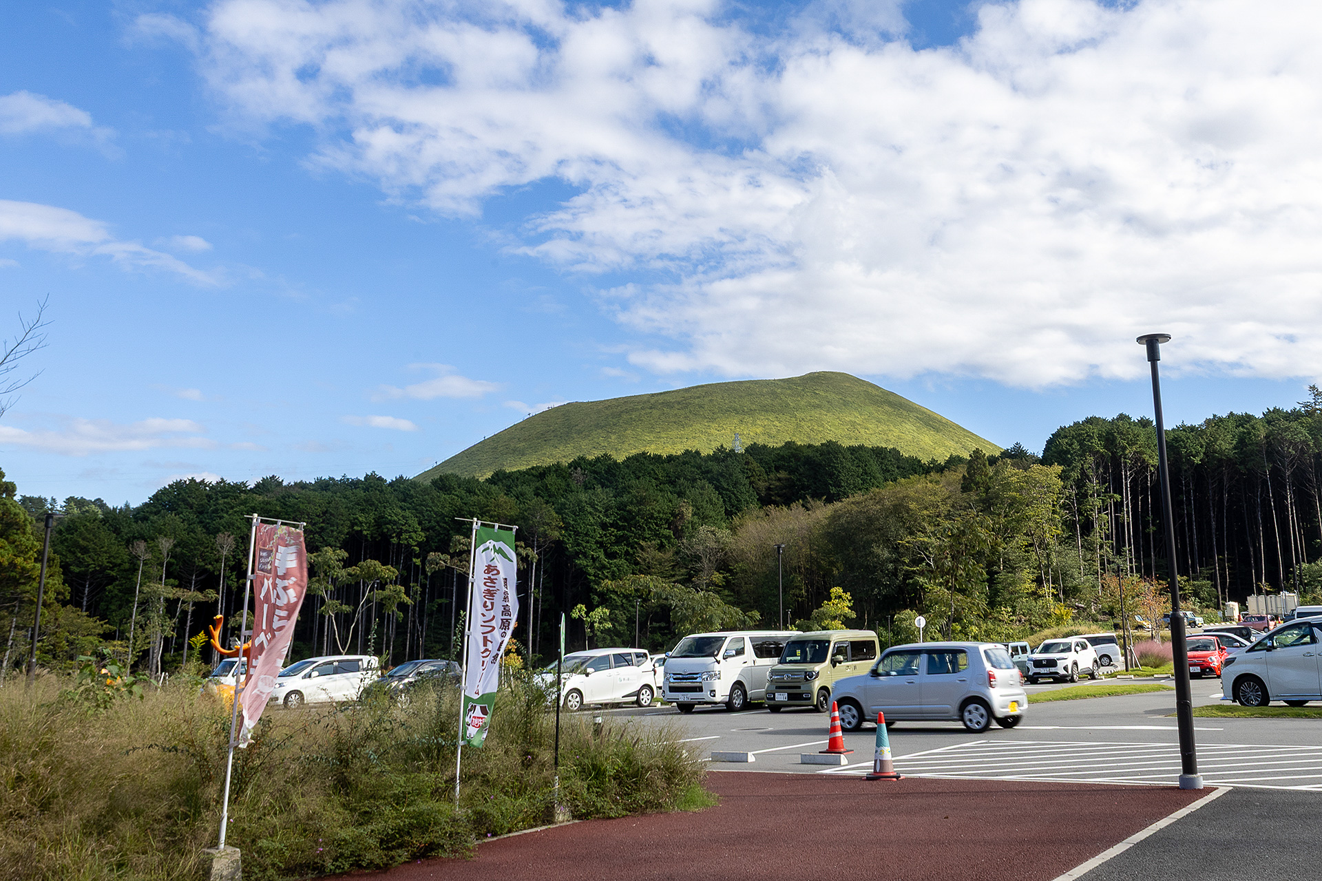 受付のある建物から駐車場を見る。奥に見えるのは名所の大室山