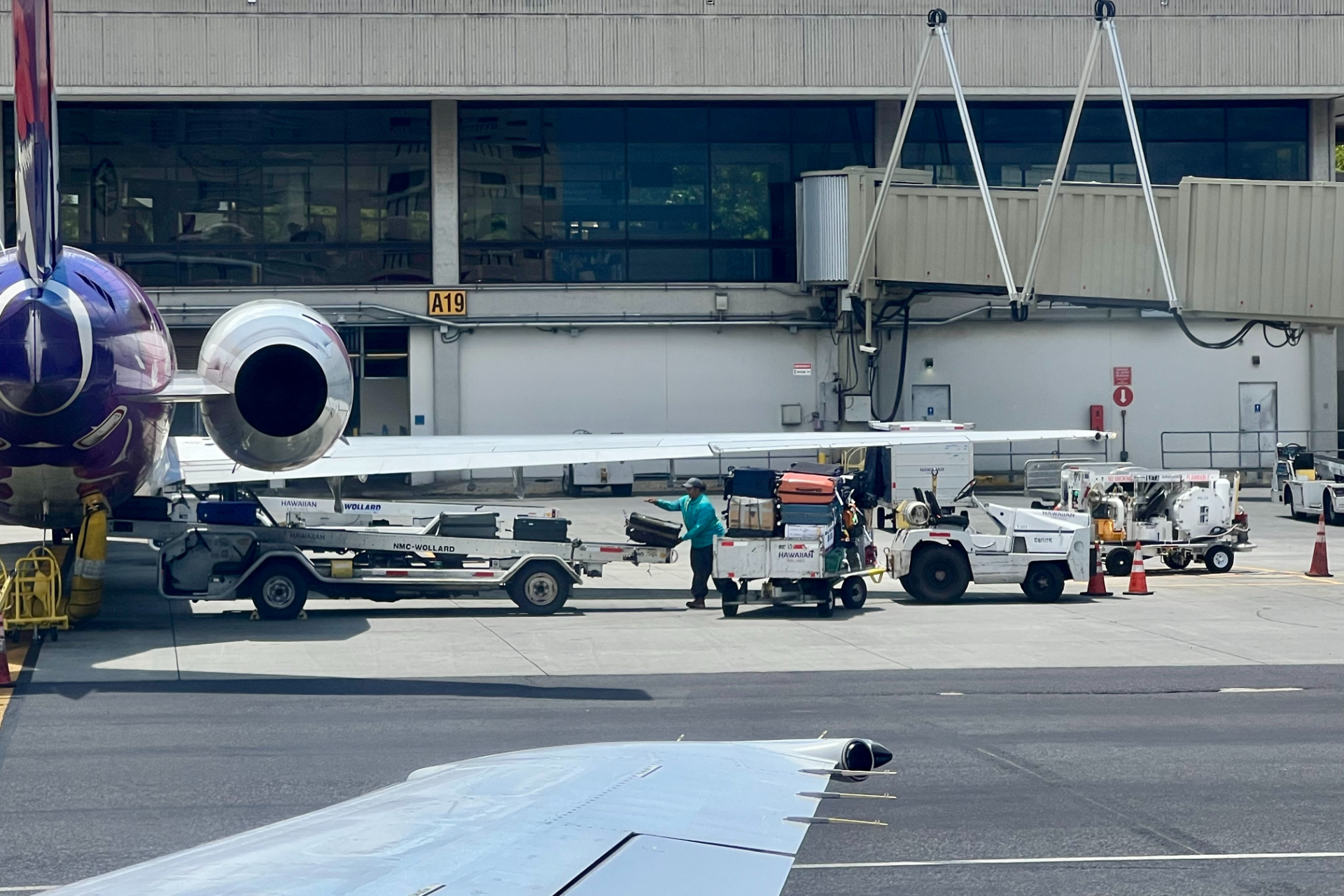 空港の職員さんたちが暑いなか手作業で荷物を積んでくれている