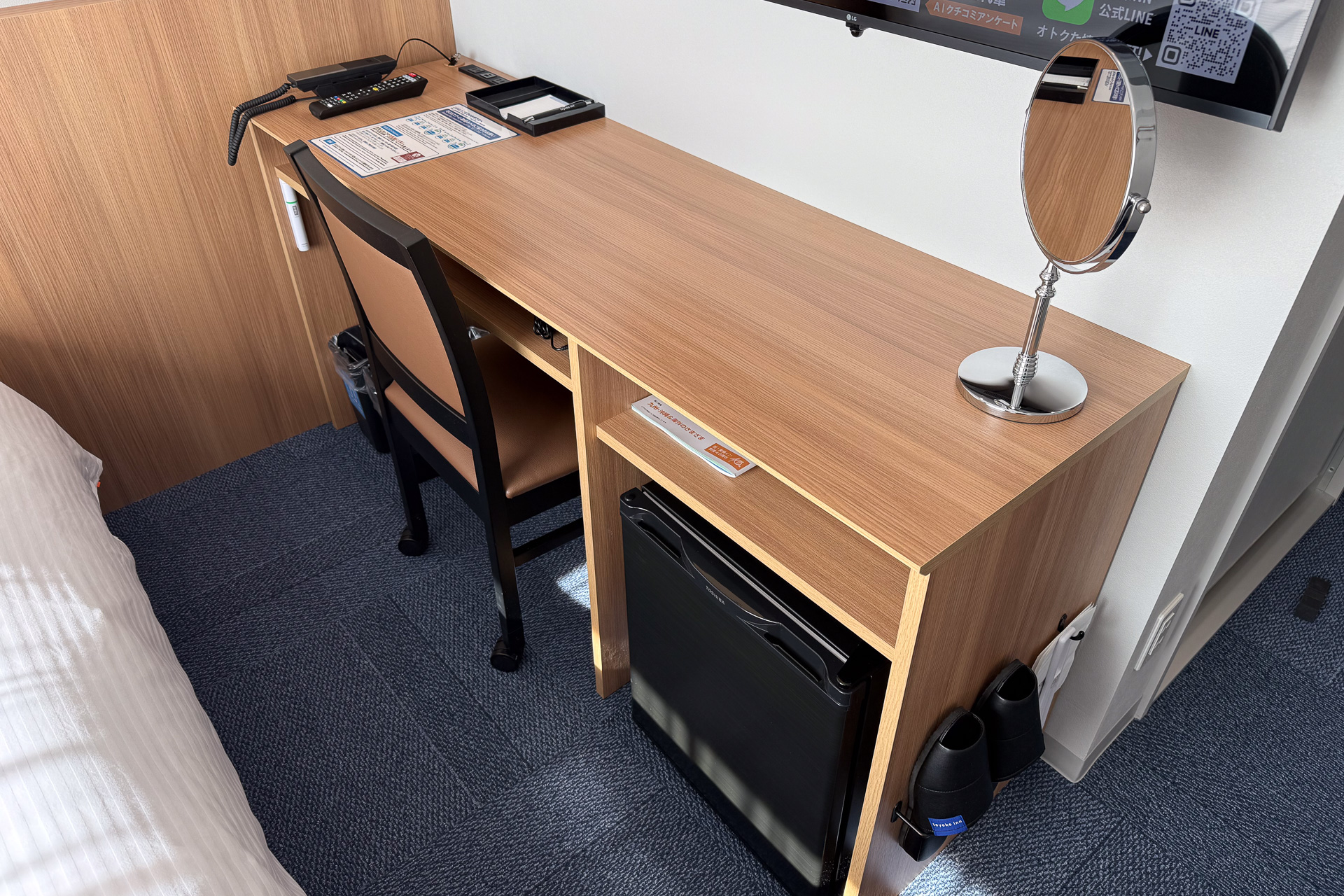 フラットで幅広なデスク。足元には冷蔵庫がある