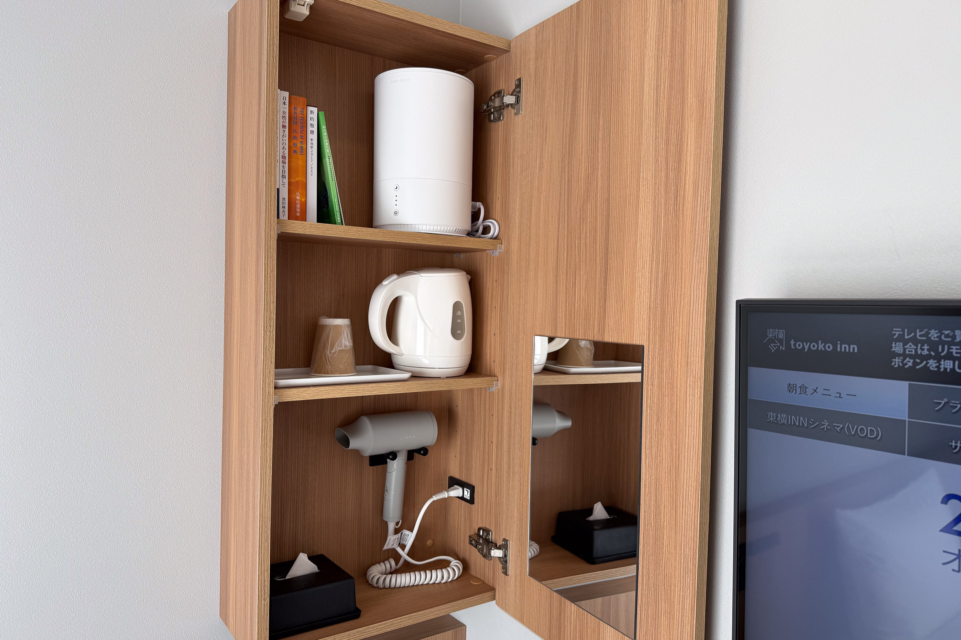 吊り戸棚にはドライヤーや鏡、電気ケトルなどを備える