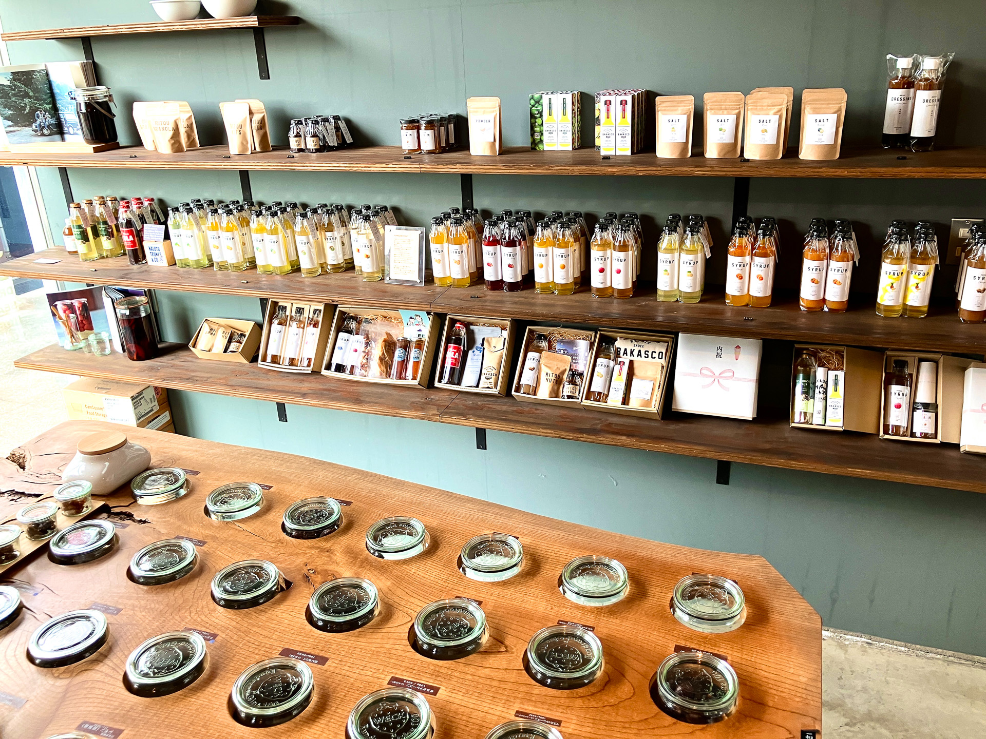 NALUTO COLAとバラエティに富んだフルーツシロップ（棚中段）、量り売りドライフルーツ（手前）