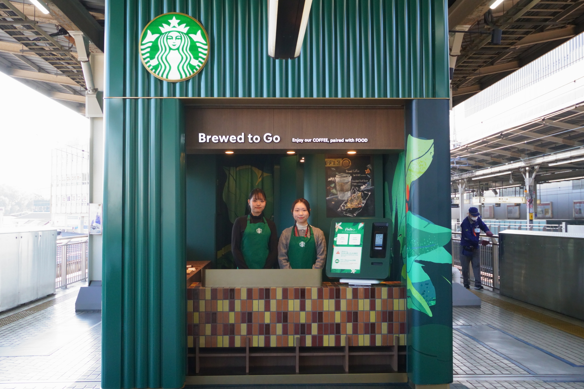 スターバックス コーヒー JR新横浜駅 新幹線下りホーム11号店の外観。4面のうち、1面のカウンター・2名のパートナー・1台の端末で、注文受付（会計）と商品の受け渡しを行なう