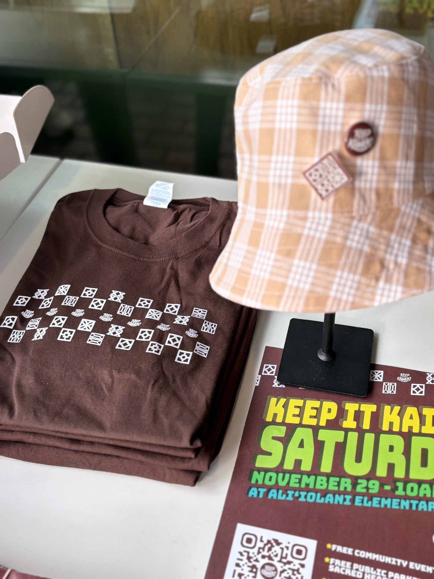 ブラウンを基調にしたロゴTシャツやパラカチェックの帽子などイベントデザインアイテム