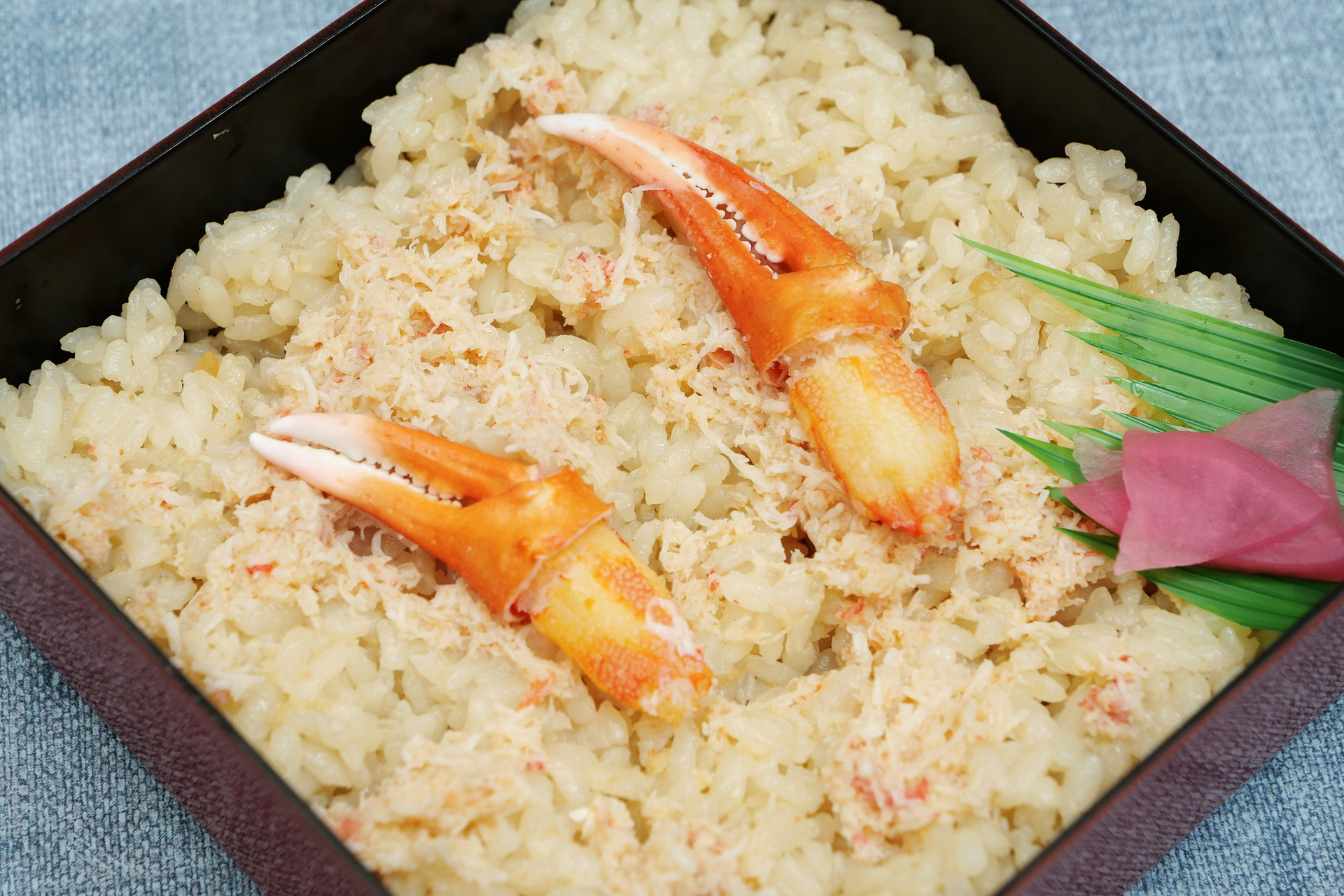 カニ風味の醤油味で炊きあげられたご飯の上に、カニのほぐし身がびっしり敷き詰められています。開けた瞬間からカニの香ばしい香りが漂ってきて食欲が高まります
