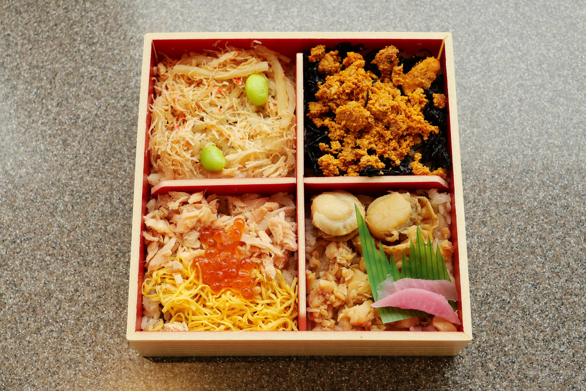 左上から、かにめし、うにめし、鮭いくらめし、帆立めしと4種類の海鮮めしが盛り付けられていて、蓋を開けた瞬間から顔がほころびます