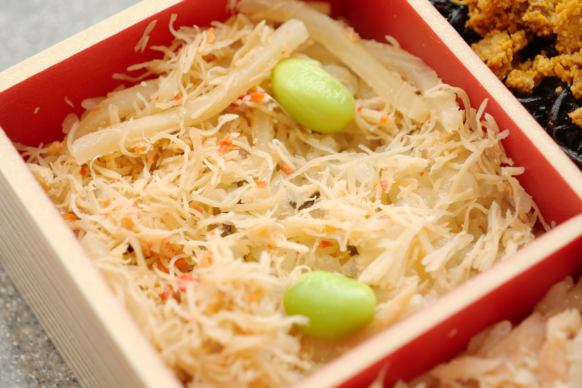 かにめしは、下の昆布めしの旨味が、甘く香ばしいカニのほぐし身の旨味をより引き立てています