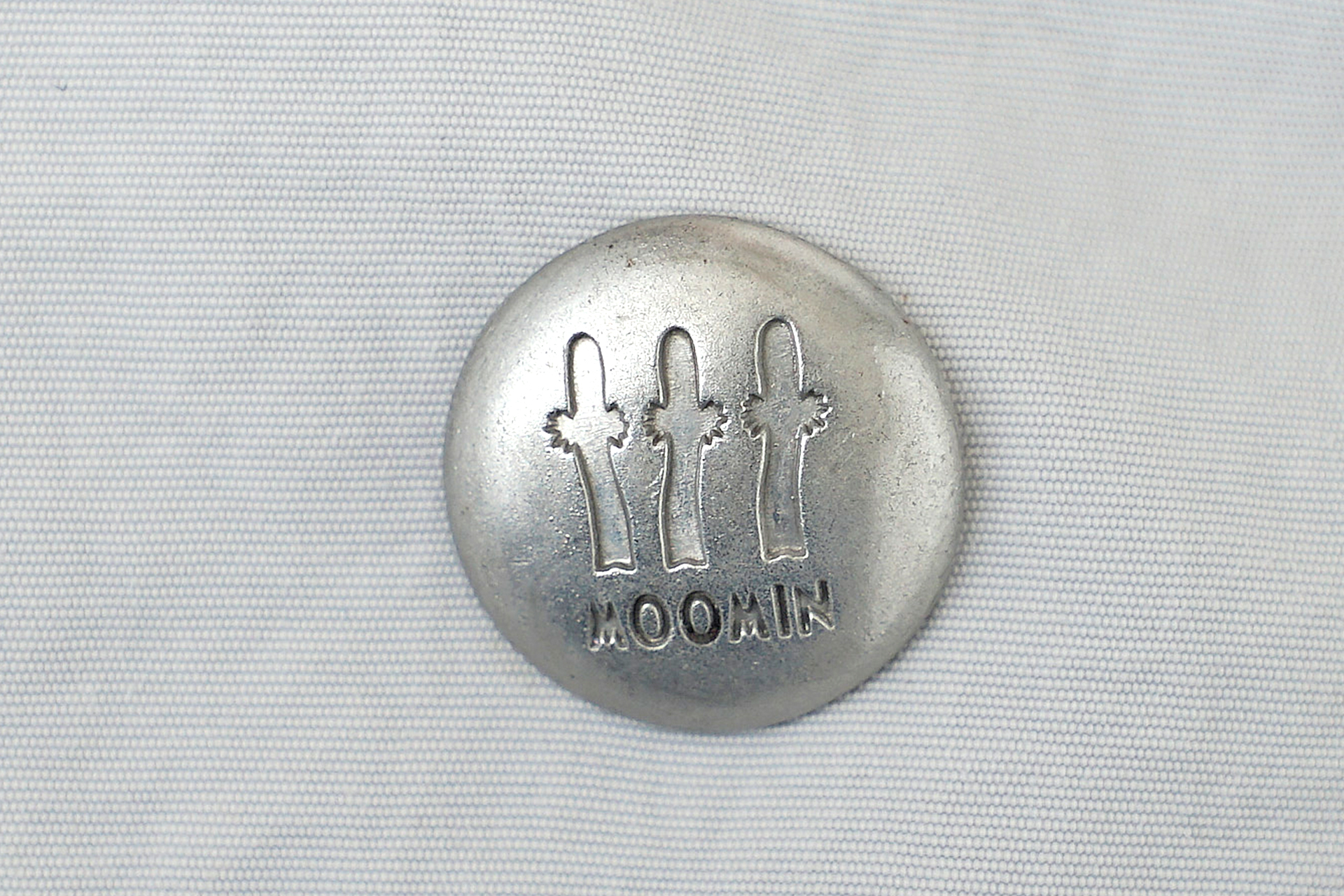 ファスナー付きの内ポケット、ニョロニョロが刻印されたボタン、ロープ風デザインの持ち手