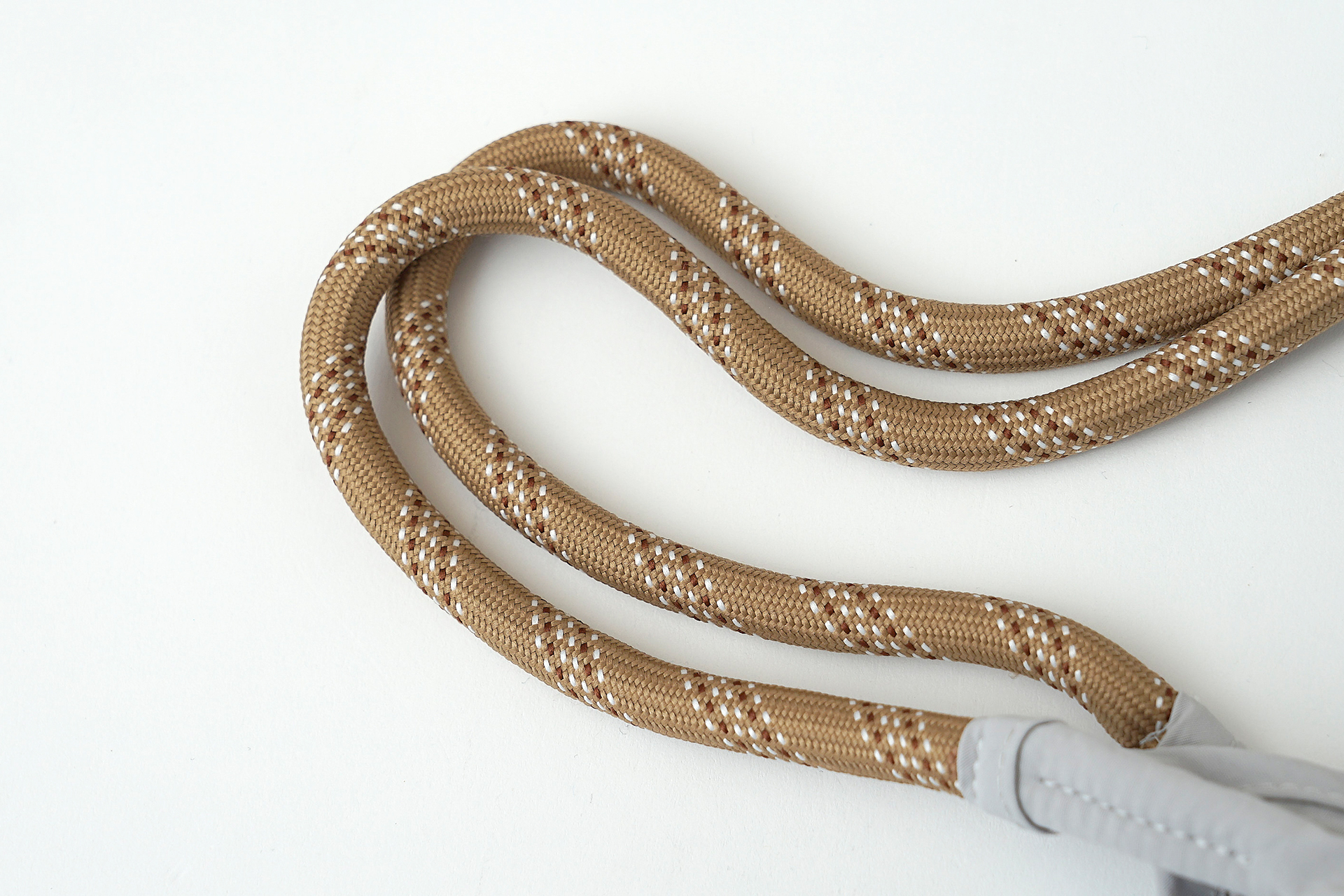 ファスナー付きの内ポケット、ニョロニョロが刻印されたボタン、ロープ風デザインの持ち手