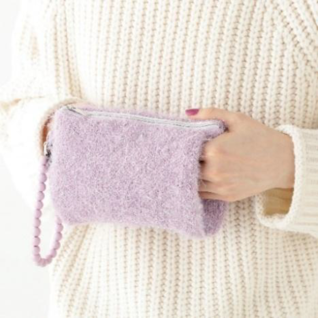 カイロをかわいく持ち運べ、両手を入れてあたたまることができるポケットも備わる