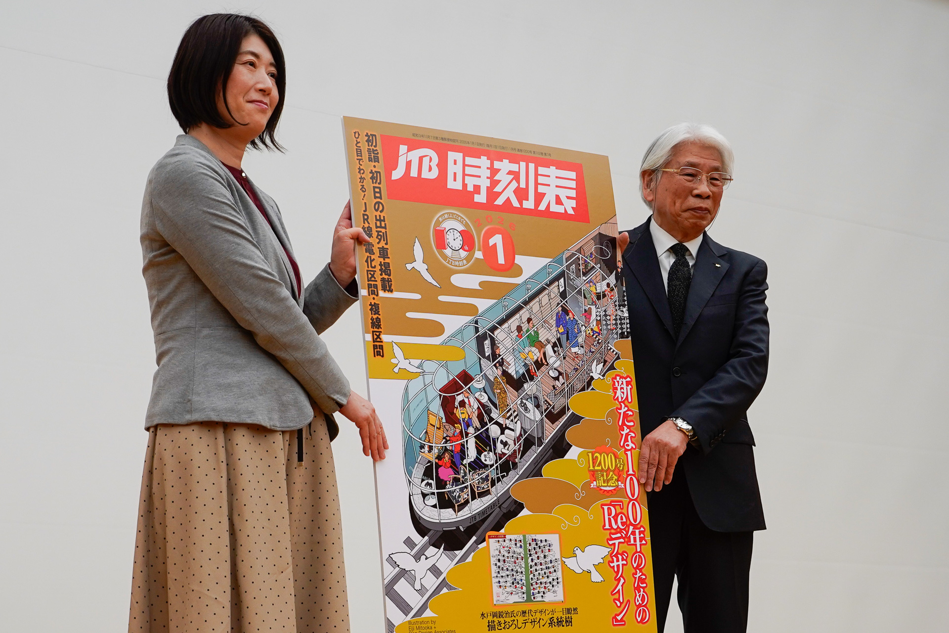 そのパネルを持って記念撮影に収まる、梶原氏と水戸岡氏