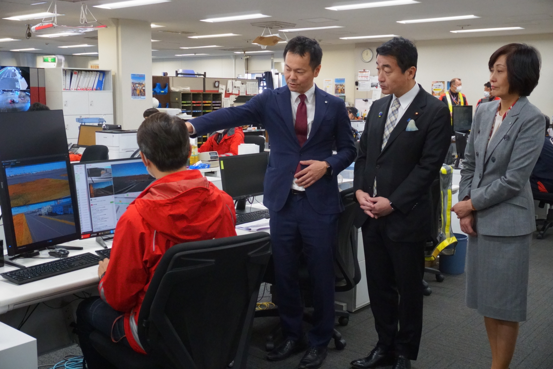 JAL貨物事務所に設置しているFMS（運行管理システム）を見学する国土交通副大臣 佐々木紀氏ら
