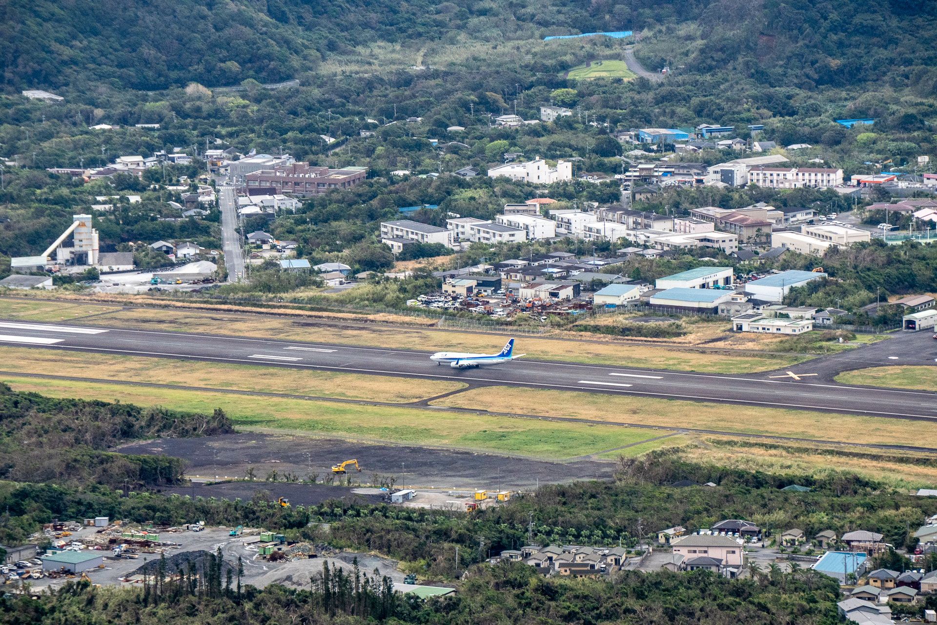 北側の八丈富士（標高853m）と南側の三原山（標高700m）に挟まれ、気流が乱れやすい八丈島の滑走路。本来各空港では、滑走路に吹く横風の風速制限（着陸の許可を決めるもの）が設定されていますが、八丈島空港では360度どこからの方向に対しても着陸できるための制限値を定めています