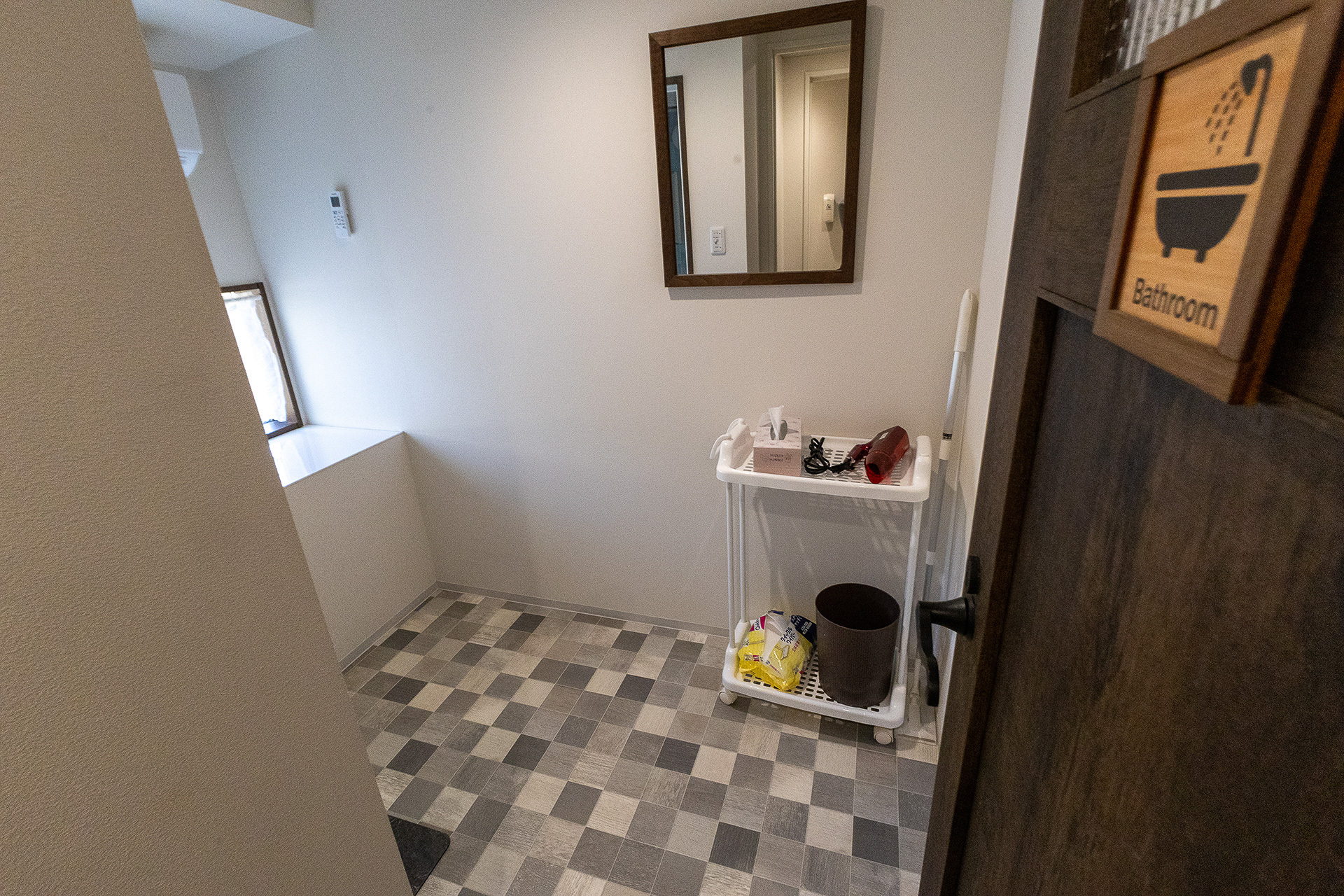 トイレの奥にもう1つ部屋があり、そこがシャワールーム。扉を開けると広い脱衣所がある。エアコンも備えている