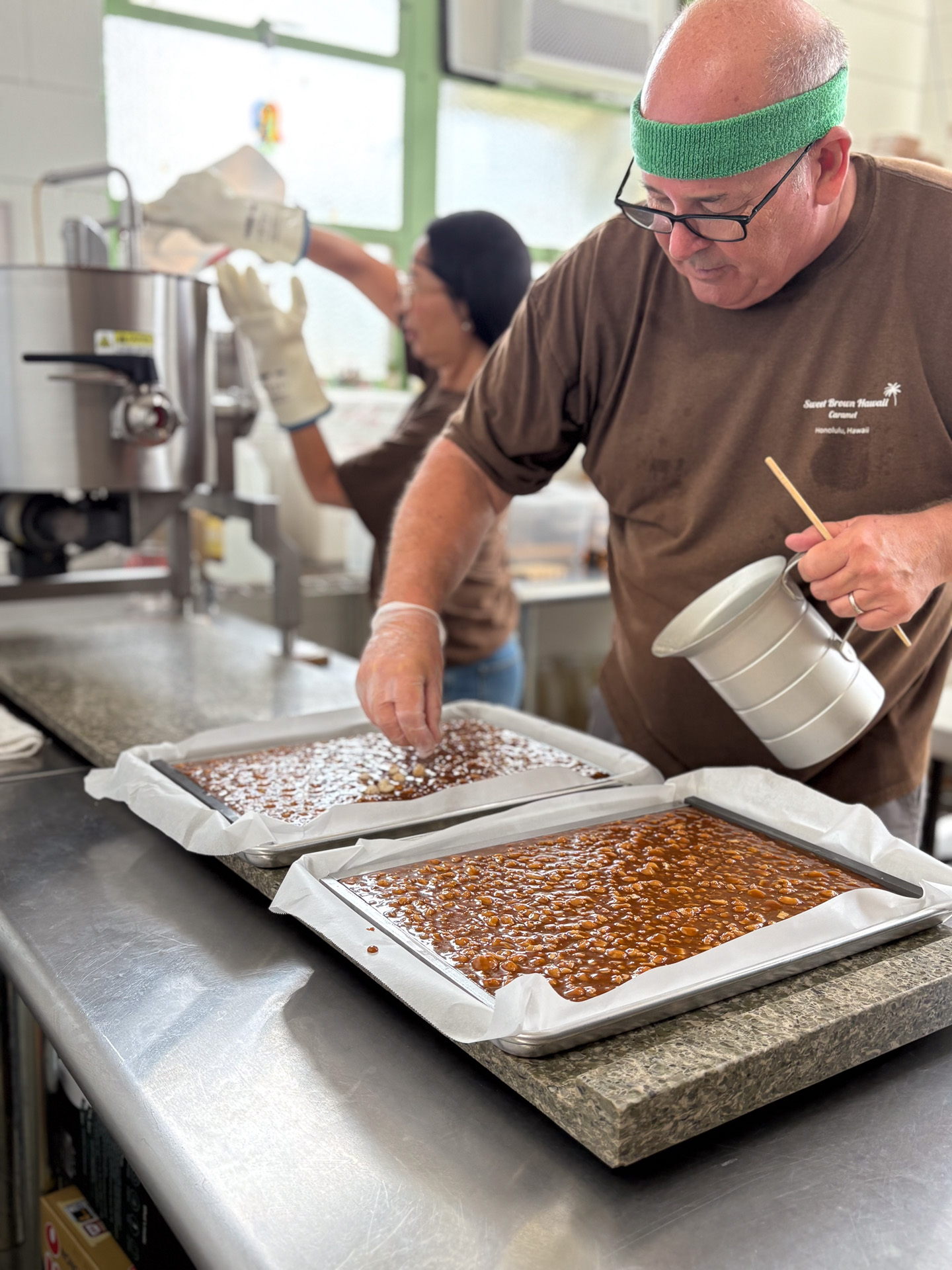 マカダミアナッツをさらに加えるスティーブさん。ルイコさんは手を添えたり、後片付けをしたりと動き回る