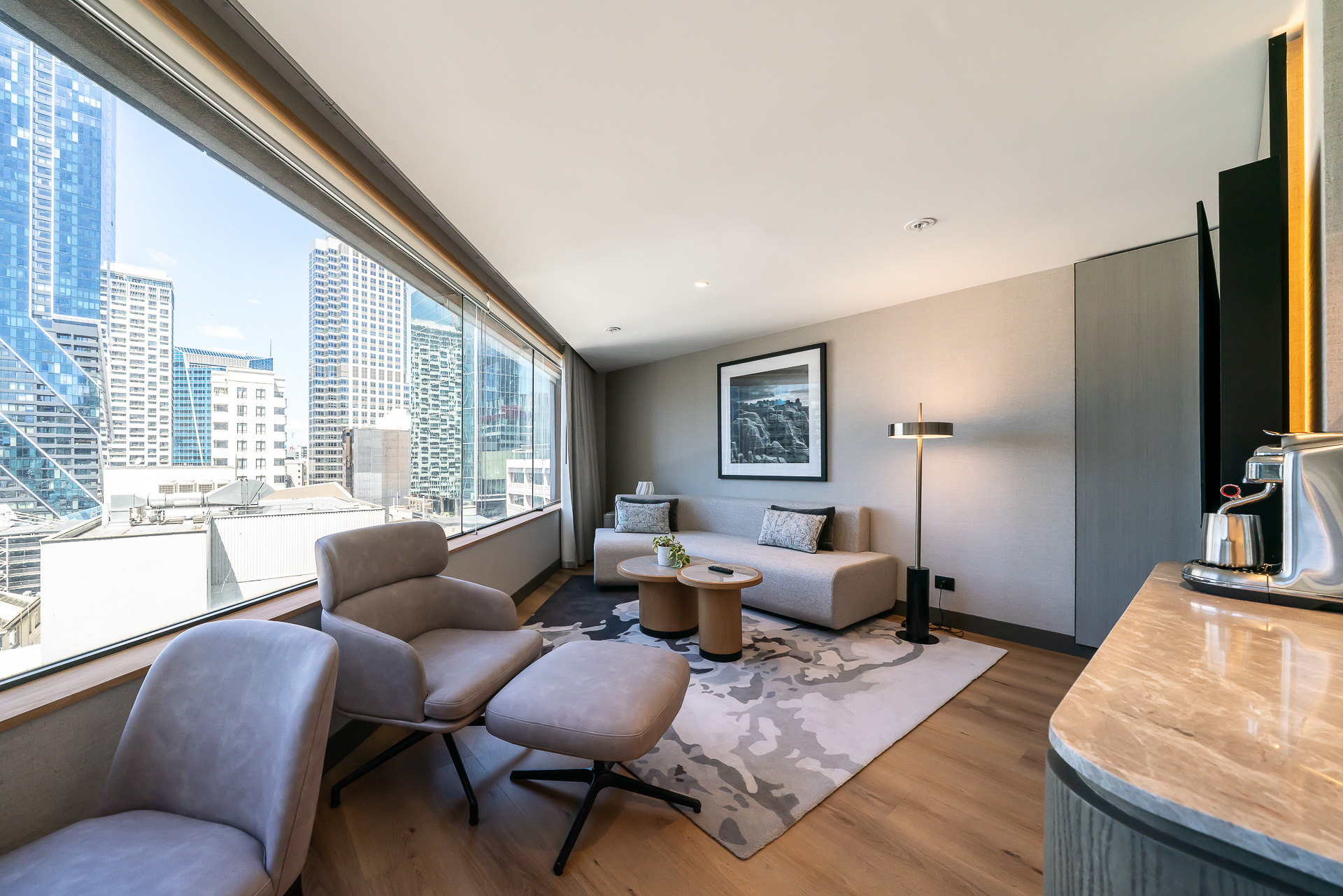 リビングルームを反対側から見たところ。大きめのソファやオットマン付きのイスなどで、ゆったりくつろげる