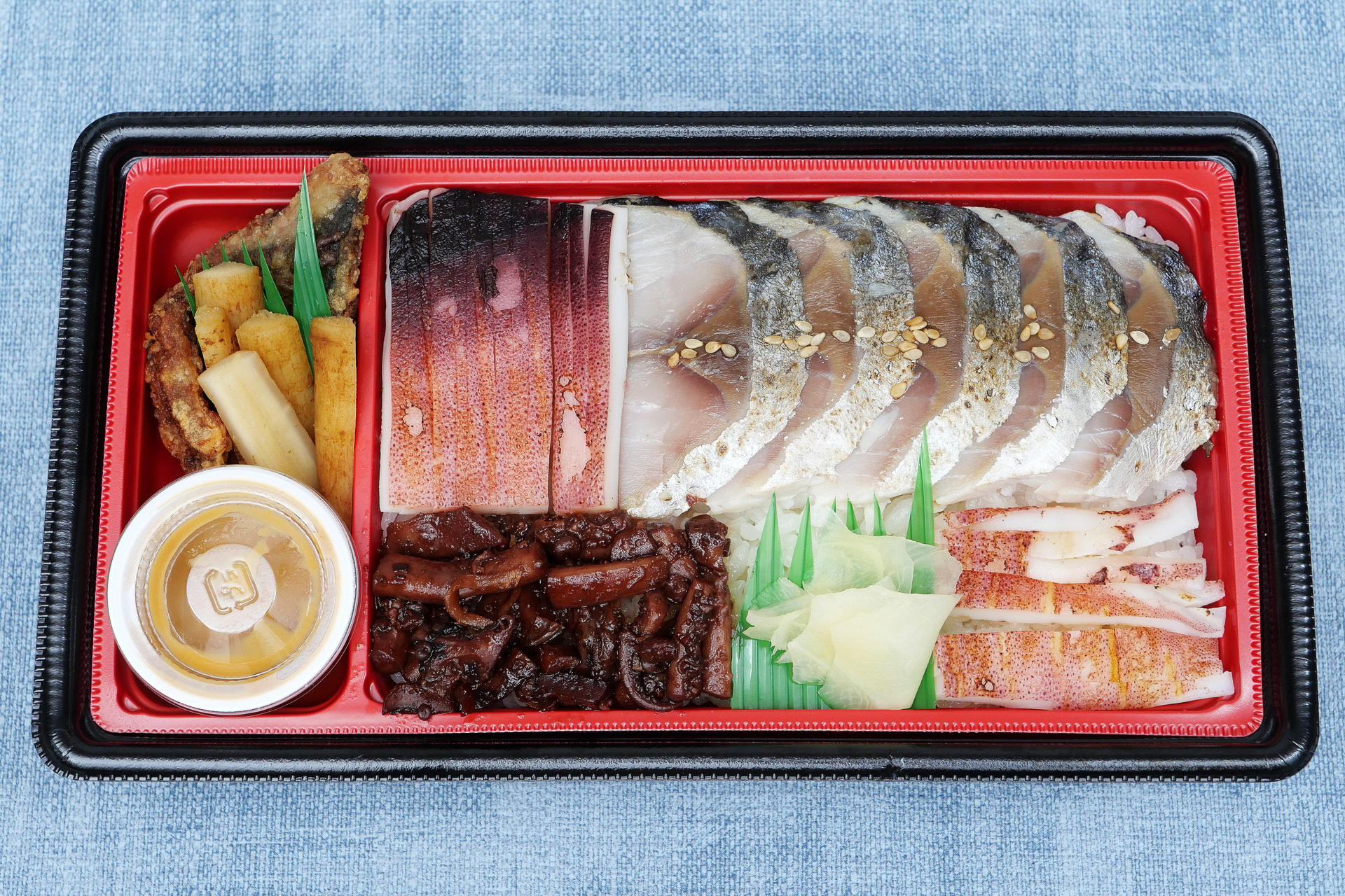 なかには、しめ鯖と鯖の竜田揚げ、イカの一夜干し風、ゲソの甘辛煮がびっしりと盛り付けられています