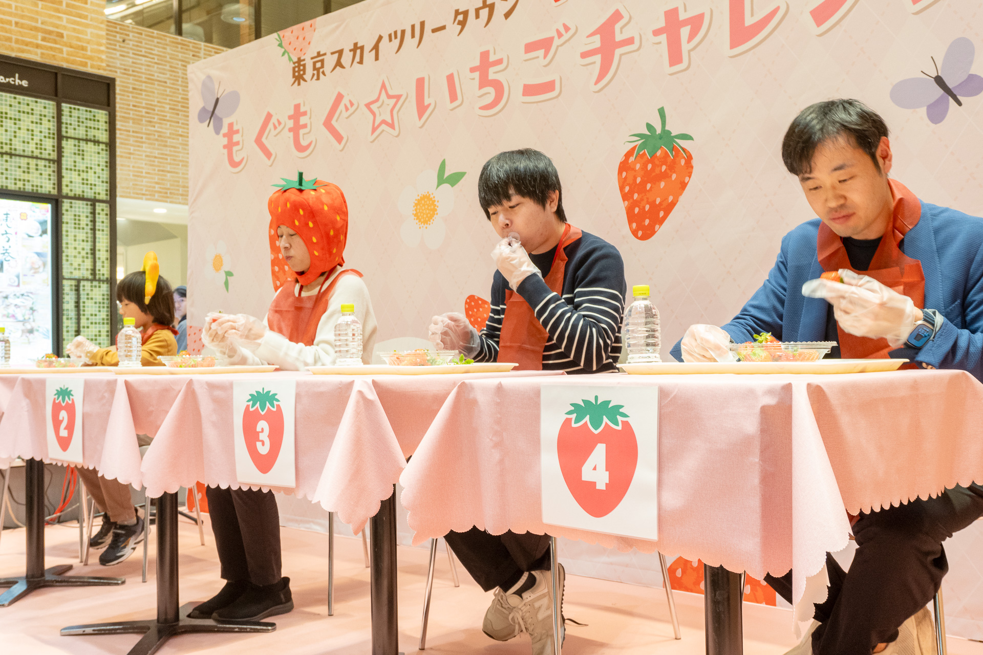 制限時間2分で、15個のいちごをいかに早く食べられるかを4人で競う