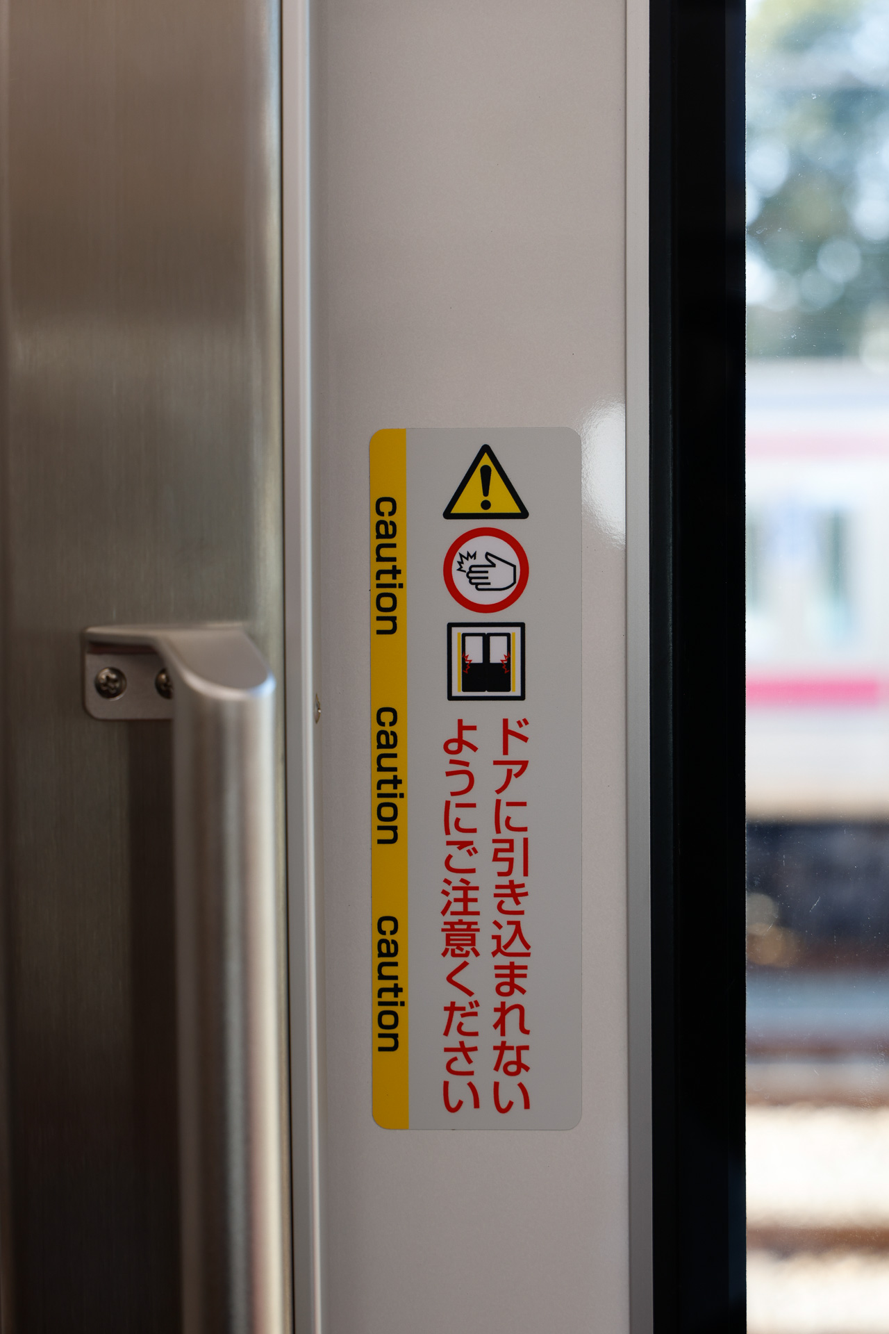 扉の端部にある、引き込まれ防止の注意喚起。これは大人の目線に合わせた、高い位置のもの