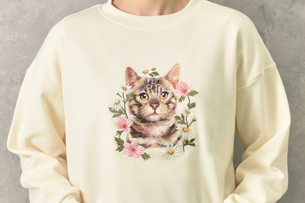 トラネコが大きくプリントされ、周りにお花が刺繍された「le petaleトラネコフラワー刺繍スウェット」。各5390円