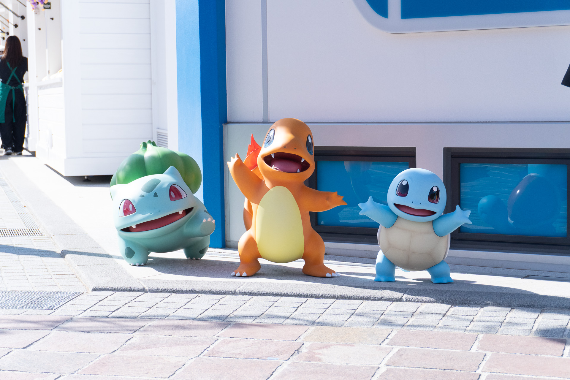 Bulbasaur, Charmander, and Squirtle, the original starter Pokémon, greet you at the storefront.