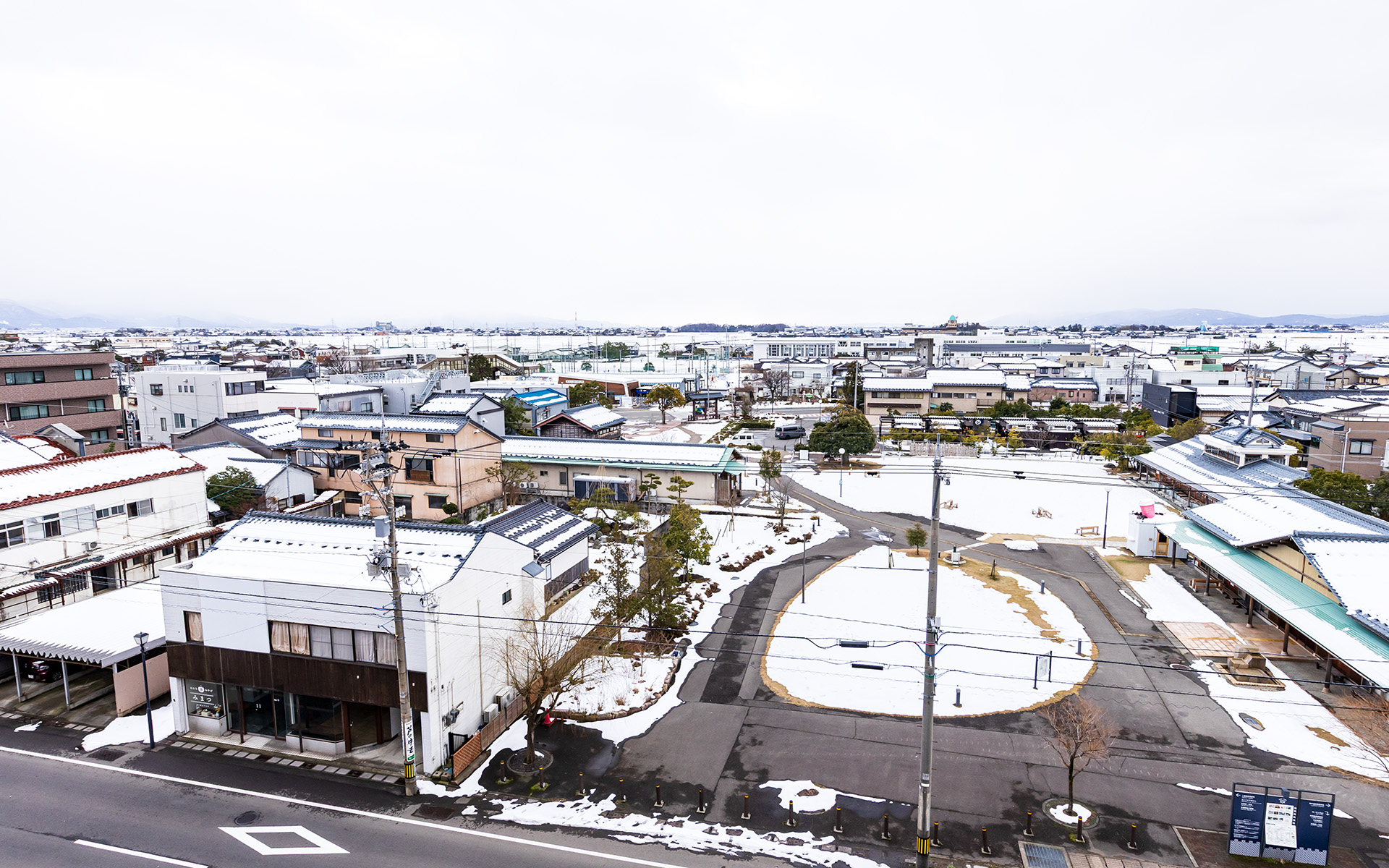 5階の客室からあわら湯のまち駅方面の眺め。手前に見えているのがあわら温泉 湯のまち広場。その奥、学校のグラウンドの手前があわら湯のまち駅になる