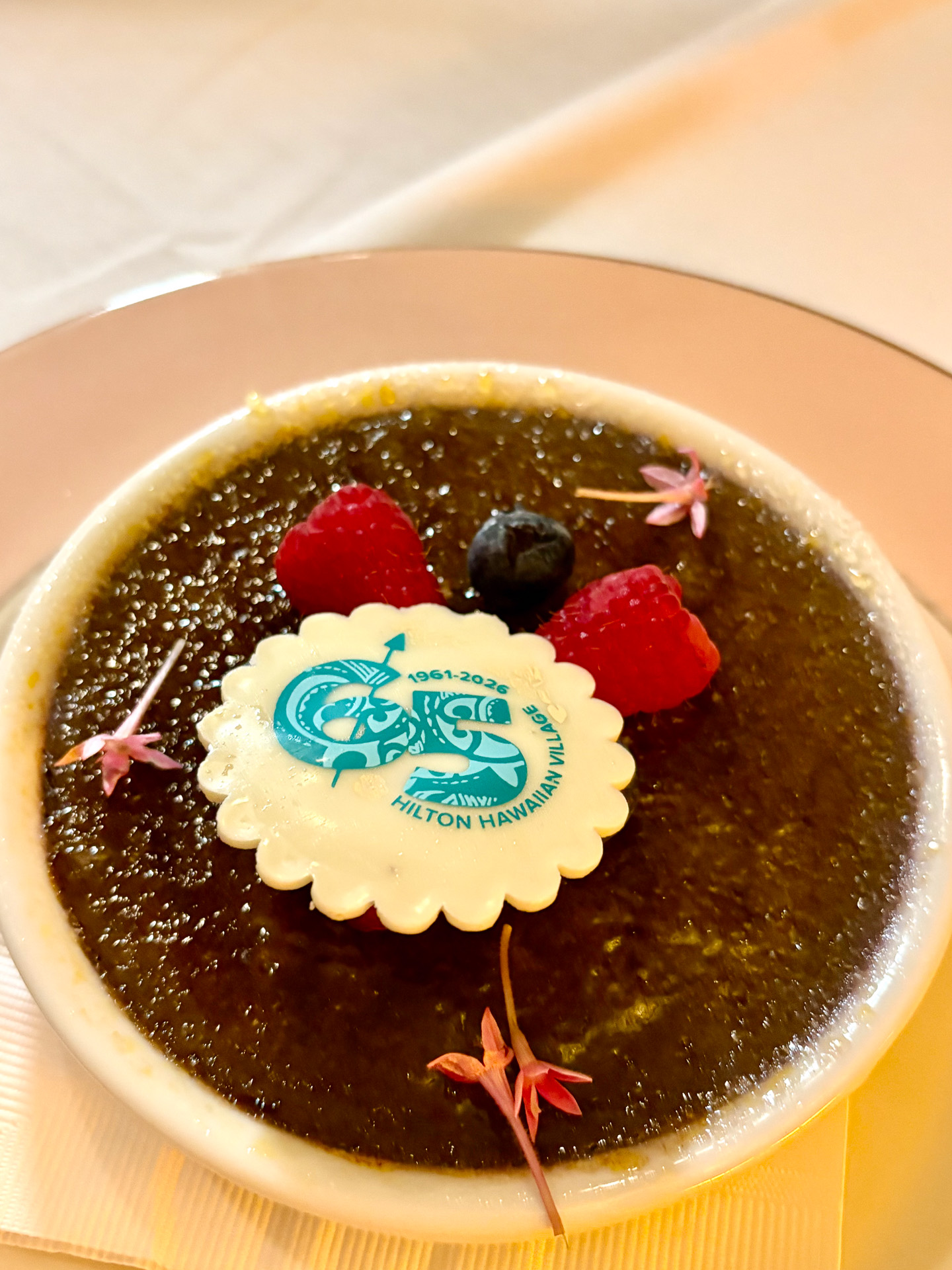 ハワイのスイーツに欠かせないウベを使ったクリームブリュレ。65周年ロゴのチョコとともに