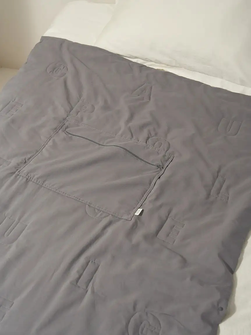 GELATO PIQUEのキルトロゴを大きくデザインした「トラベルブランケット」（ピンクとグレー、各8580円）。中綿入りでふんわり、使わないときはクッションにもなる