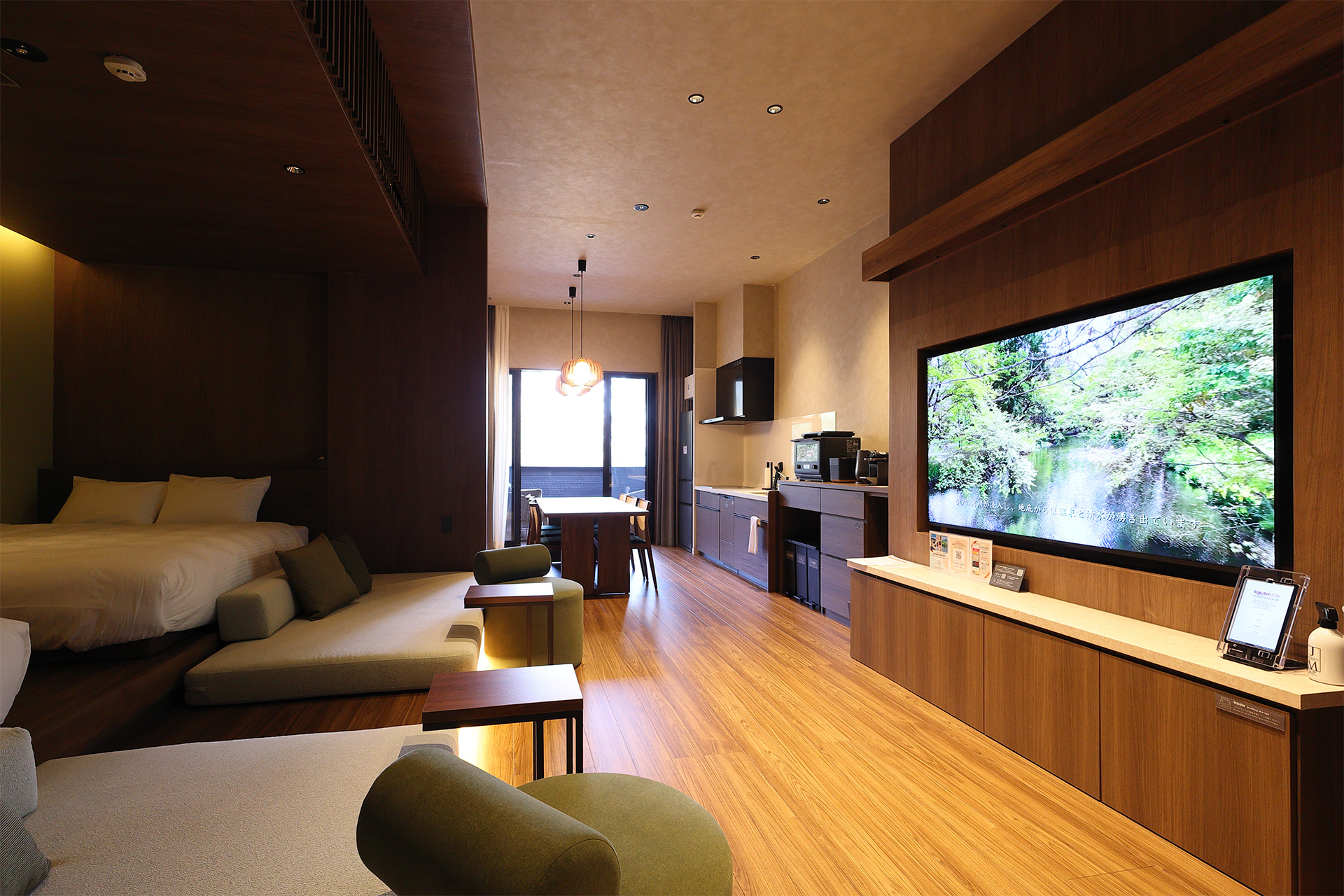 【Cタイプ】リビング。右側にはテレビ、左側の壁際にはクイーンサイズのベッド