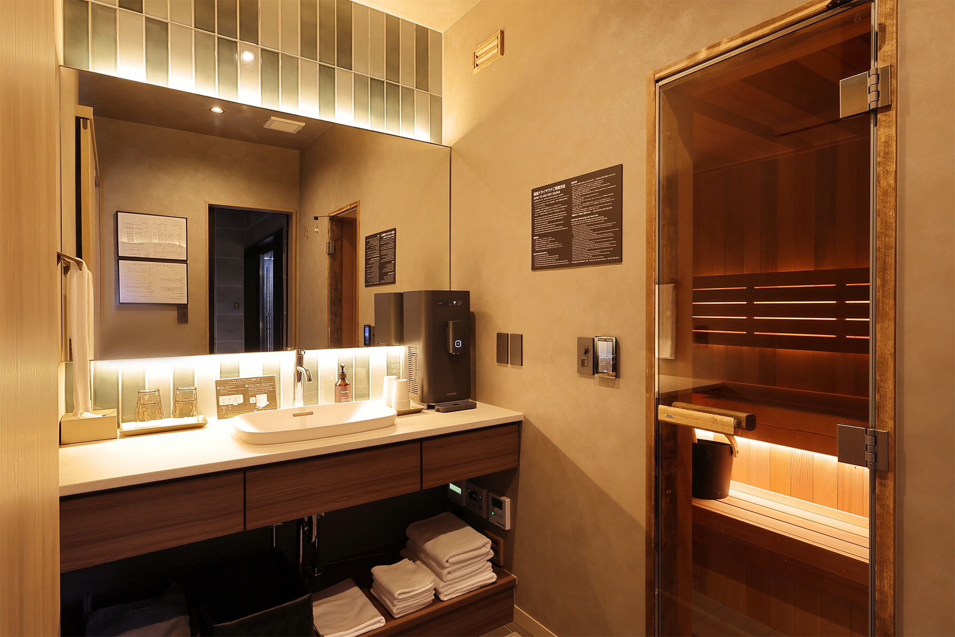サウナ室の外にはウォーターサーバーを用意しているので水分補給もこまめにできる。タオル、ルームウェアは洗面台の下に用意していた
