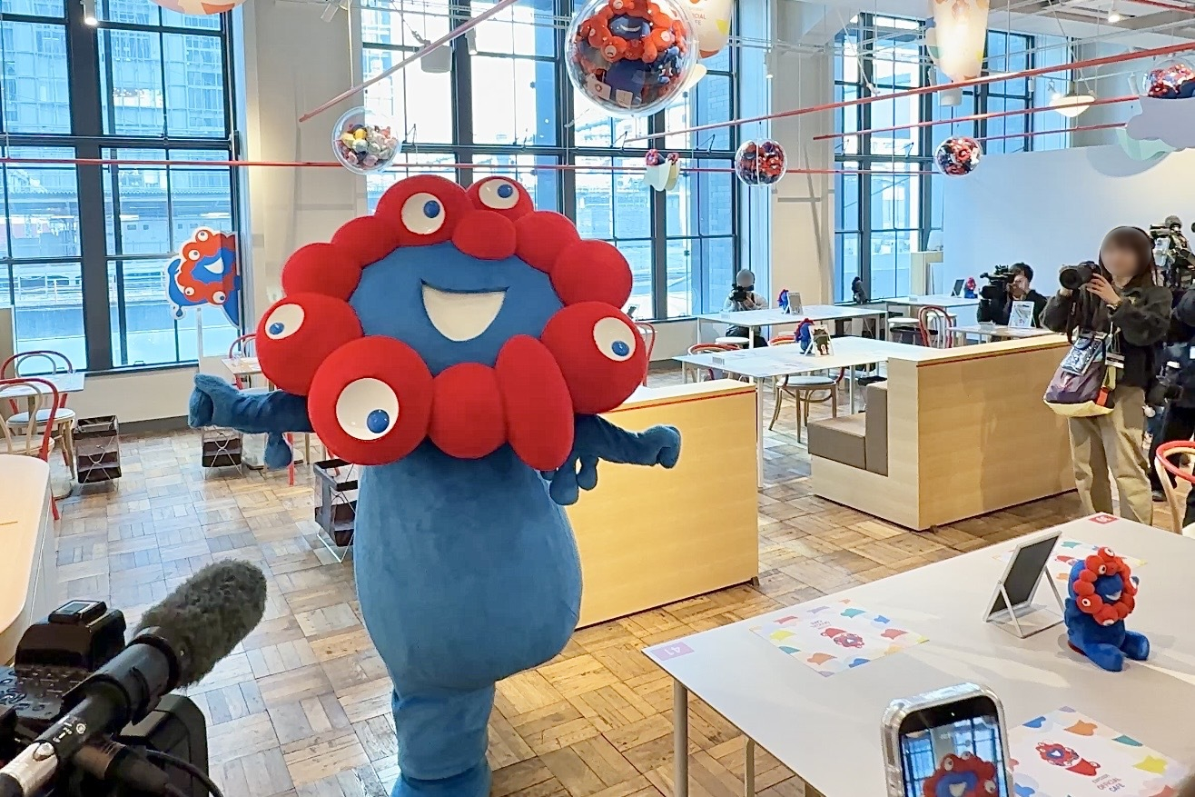 あちこちに飾られているぬいぐるみやランチョンマットを見て喜ぶミャクミャク