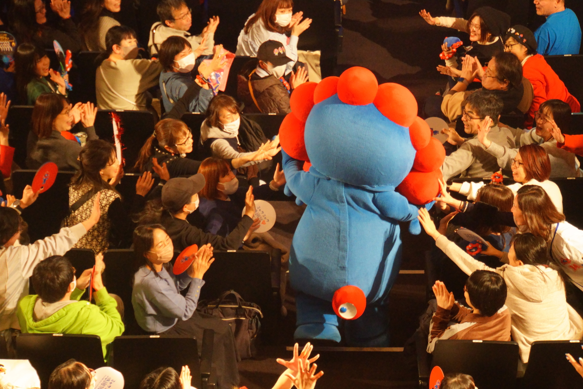 客席中央の通路から登場したミャクミャク。ファンとハイタッチしながらステージへ向かう